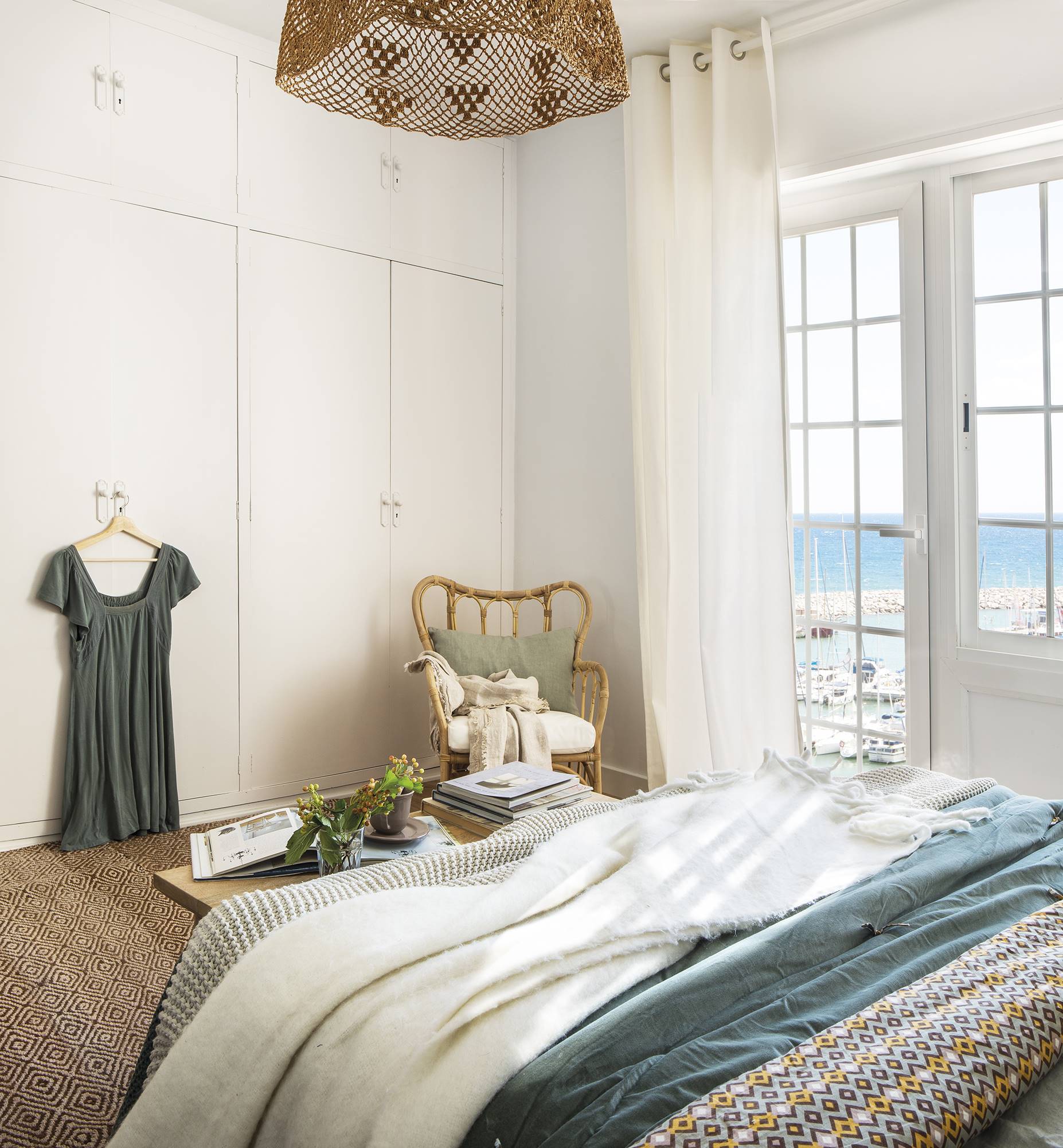 Dormitorio pequeño blanco con vistas al mar 
