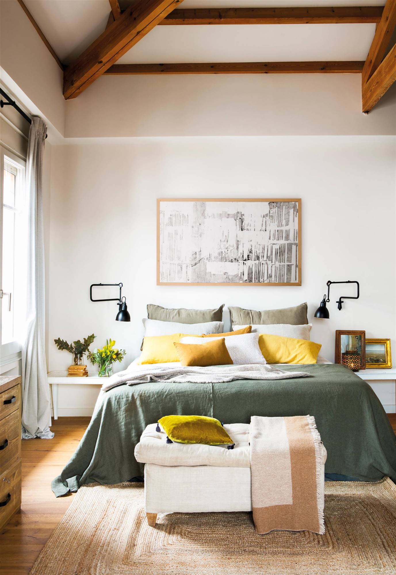 Dormitorio con mesillas idénticas, ropa de cama verde y amarilla y banqueta mullida en los pies de la cama. 