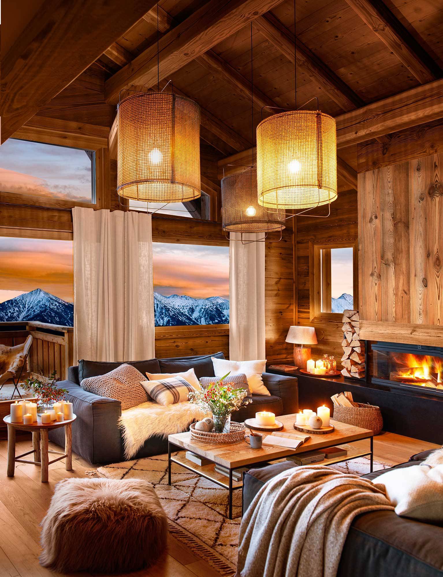 Salón de cabaña de madera revestida de madera y con lámparas de techo iluminadas.
