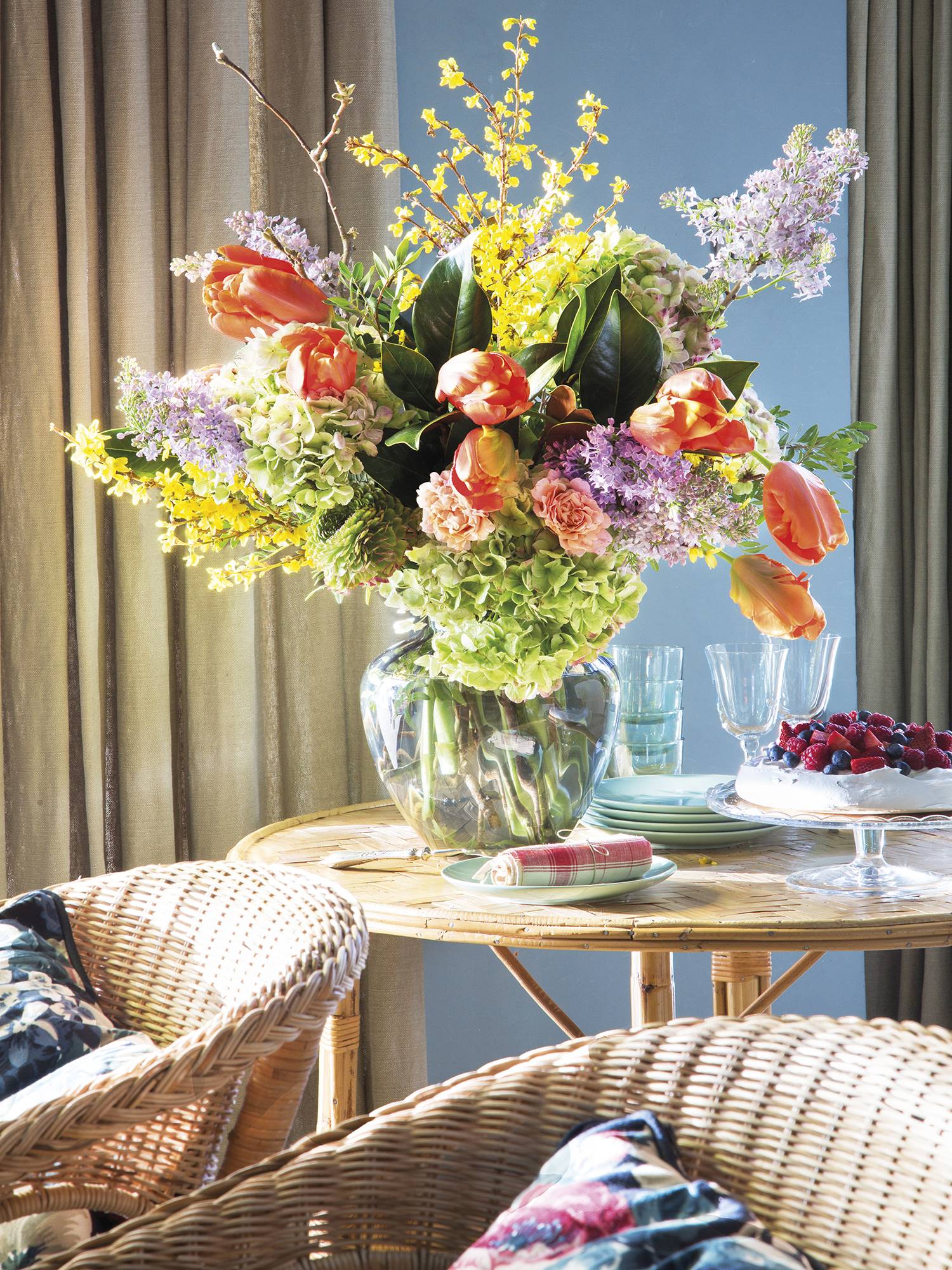 Mesa auxiliar con jarrón de cristal y flores y una tarta. 