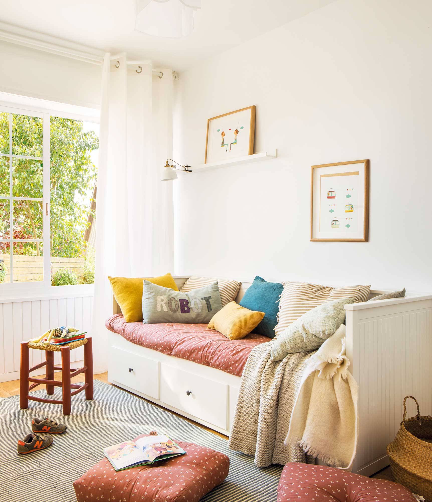 Dormitorio infantil con cama con cajones en blanco y nórdico a juego con los cojines.