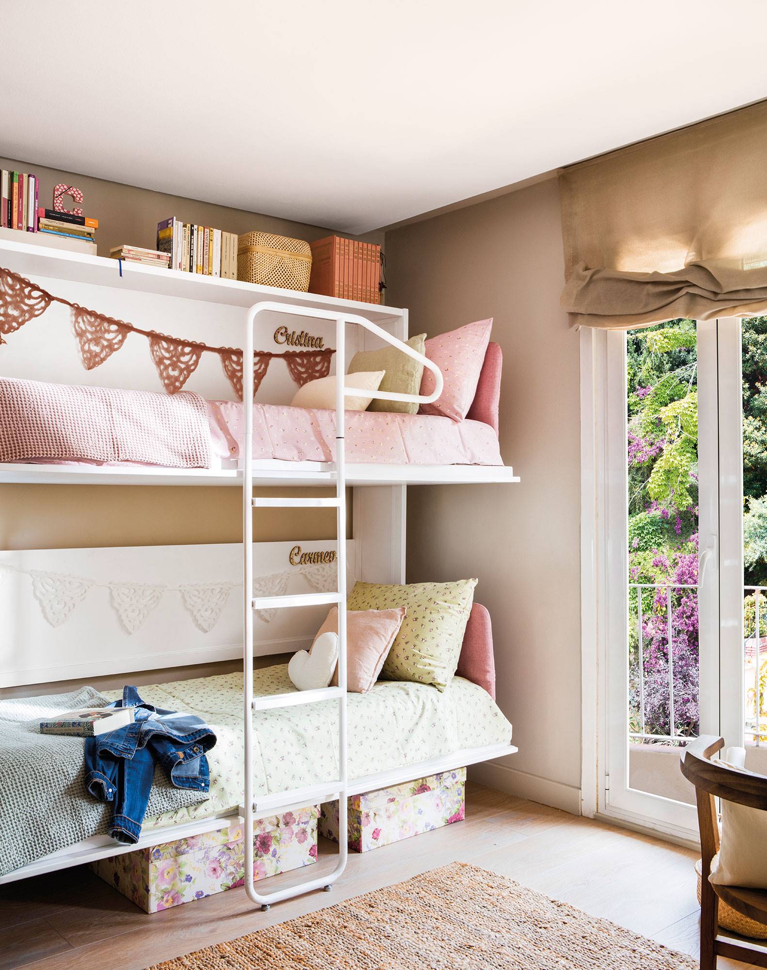 Dormitorio infantil con literas de hierro y ropa de cama en verde y rosa.