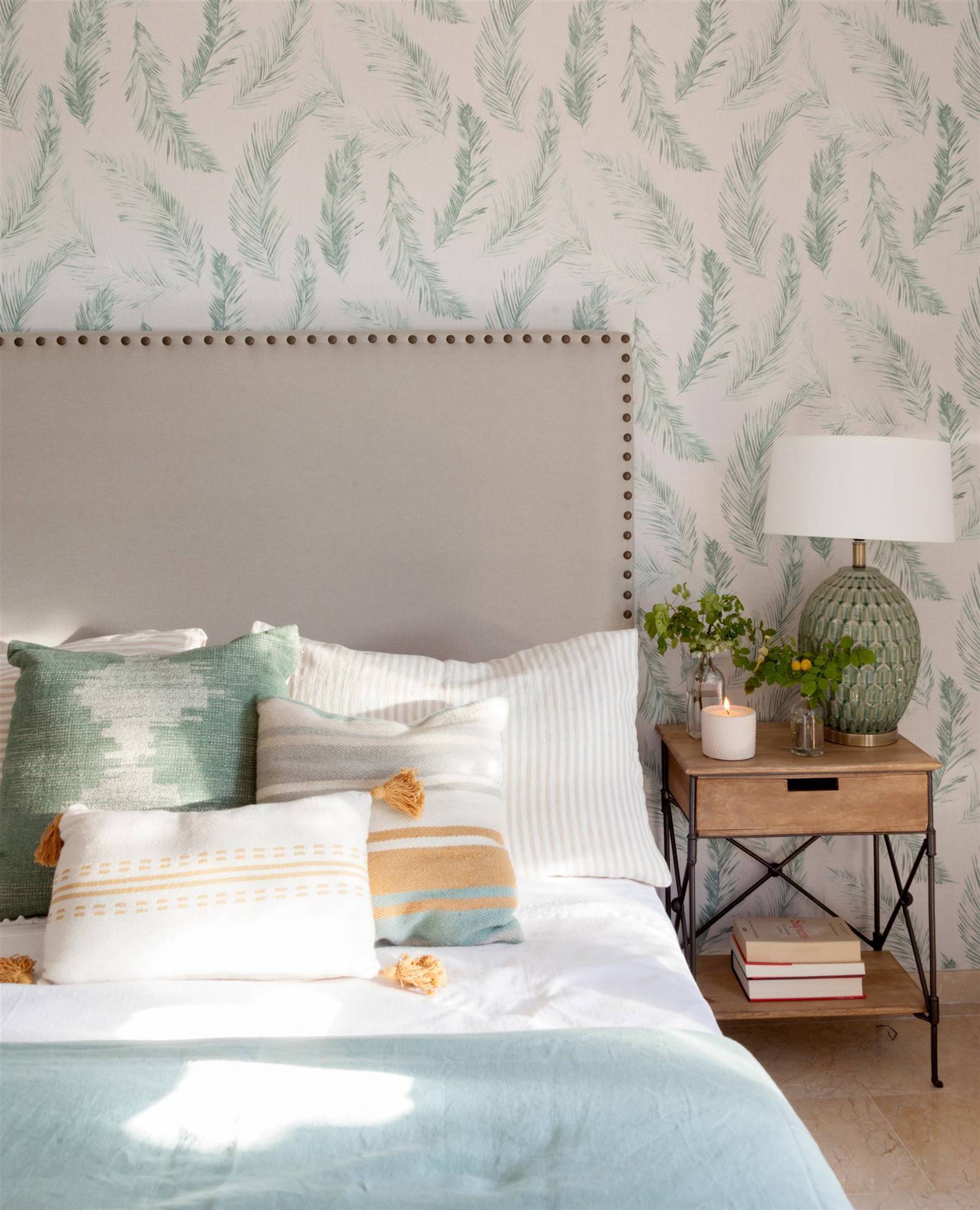 Dormitorio con papel pintado de plumas en el cabecero. 