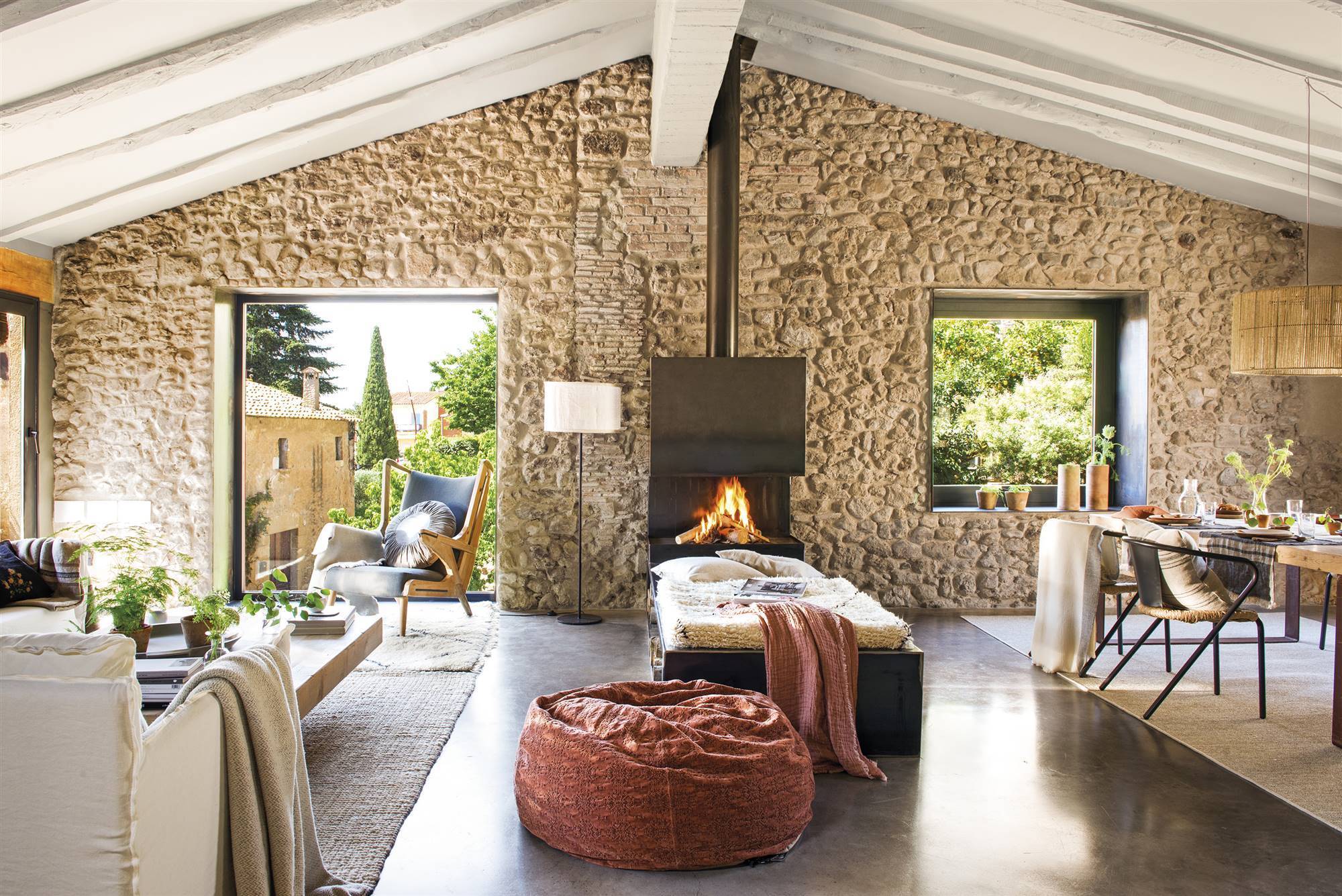 Salón de casa de campo moderna con paredes de piedra