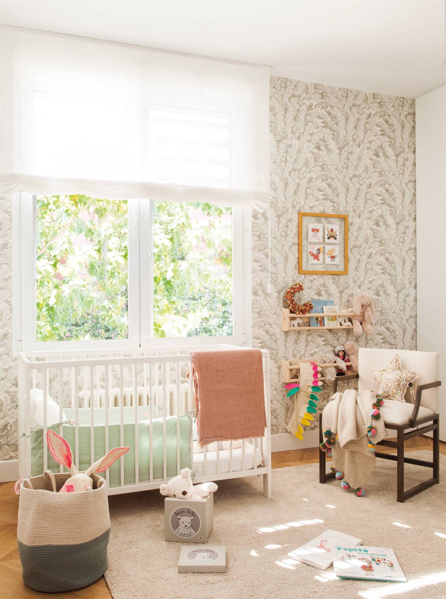Habitación de bebé con papel pintado, cuna y butaca