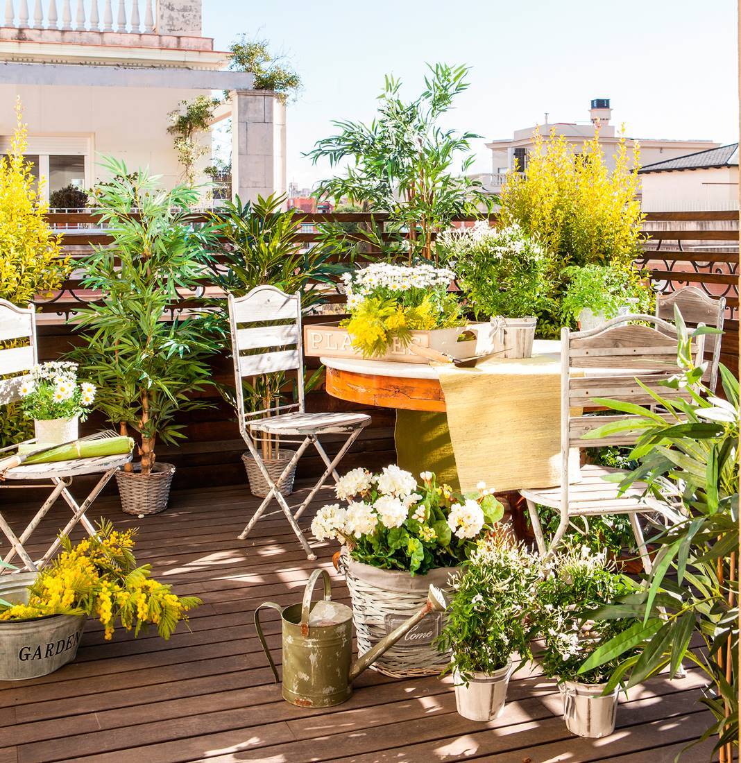 Terraza pequeña con suelo de tarima, sillas de jardín vintage, plantas y flores 5ee9ef7b 5664f304 1068x1100