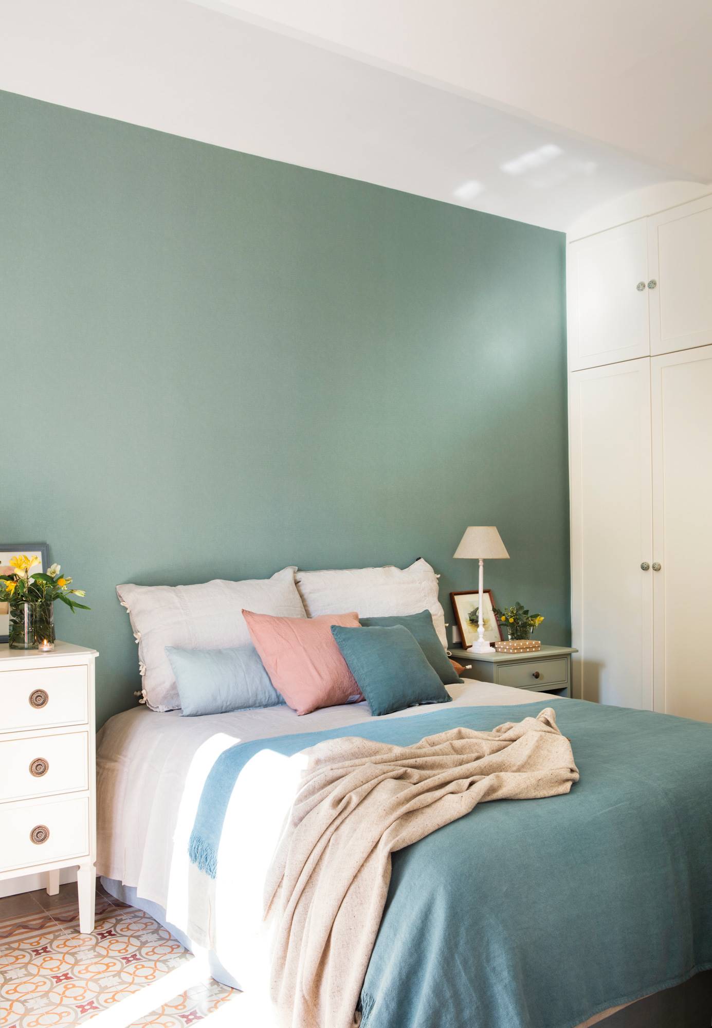 Dormitorio con la pared del cabecero pintada de azul. 