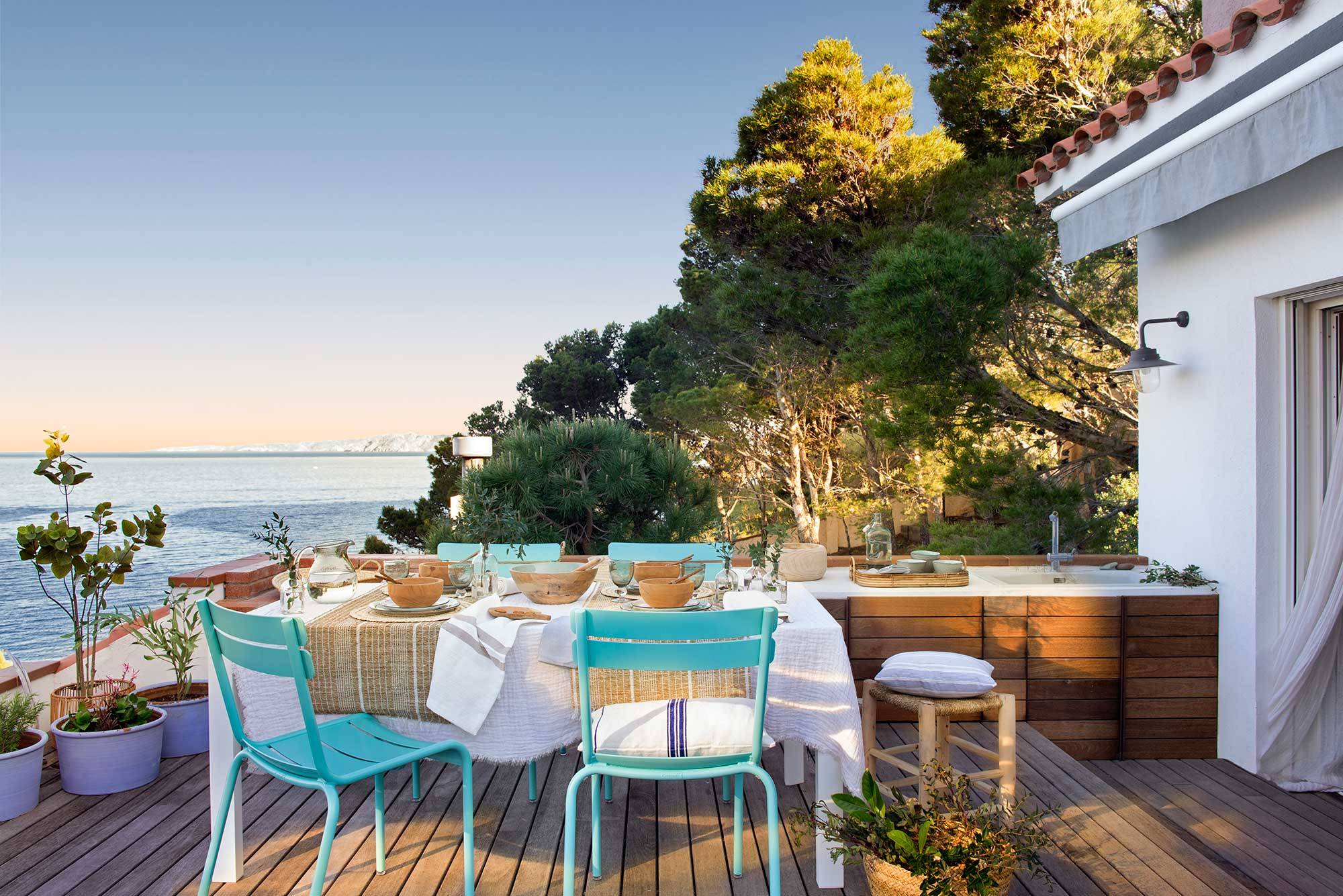 Terraza de apartamento de verano con vistas al mar y cocina de exterior.