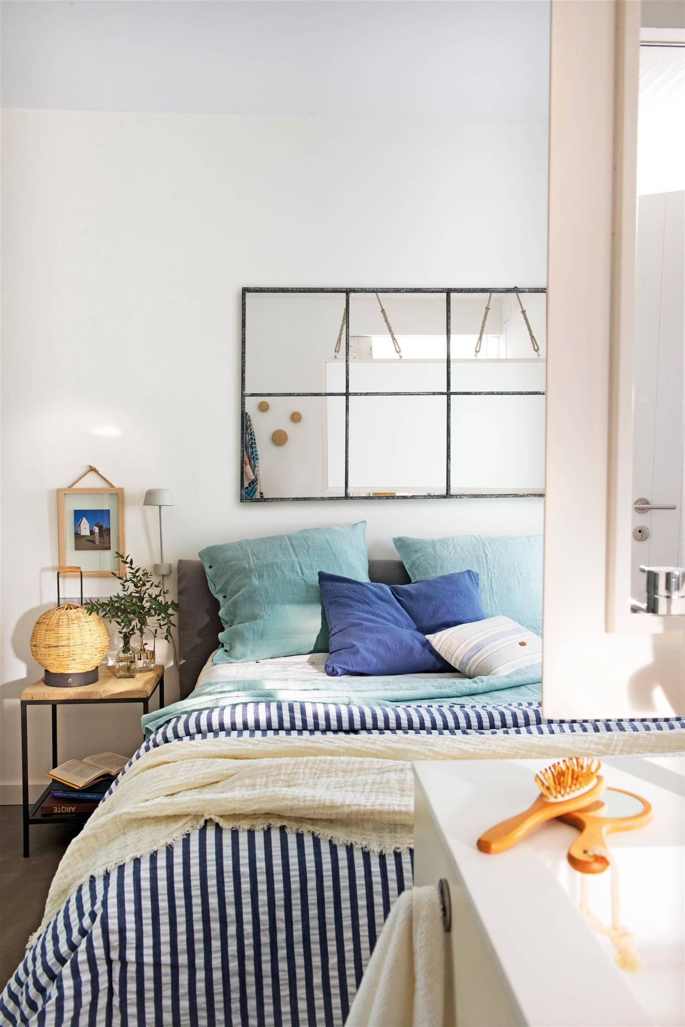Dormitorio de verano con ropa de cama en tonos azules y espejo con marco metálico y cuarterones 00507550