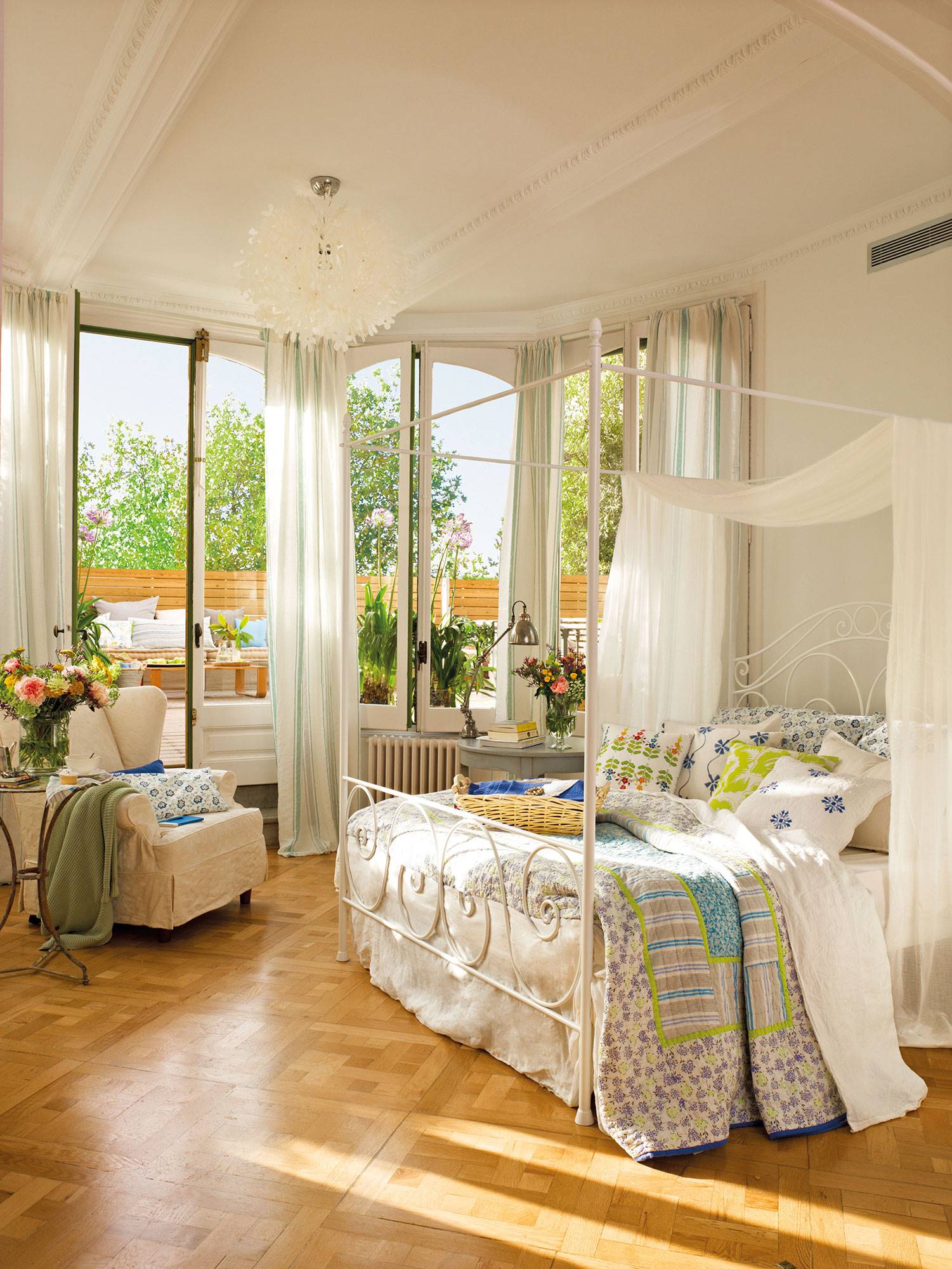 Dormitorio clásico con cama con dosel, terraza y ropa de cama con flores. 