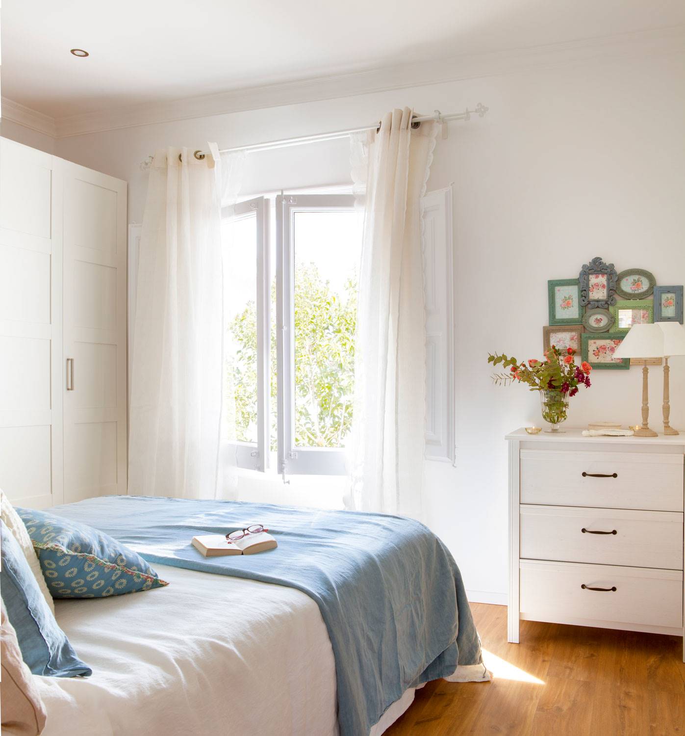 Dormitorio con armario y cómoda blancos. 