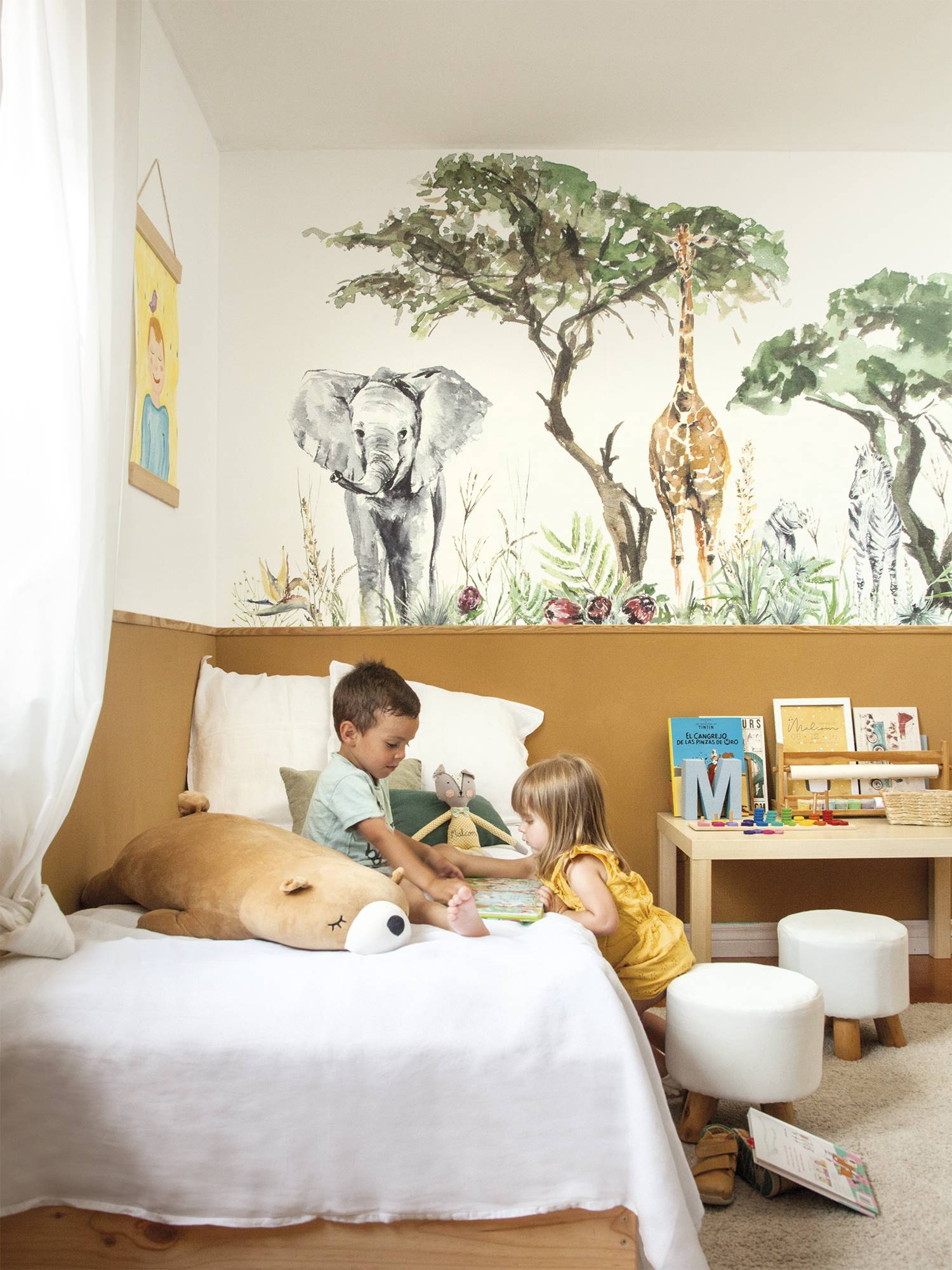 Dormitorio infantil con mural de animales en la pared. 