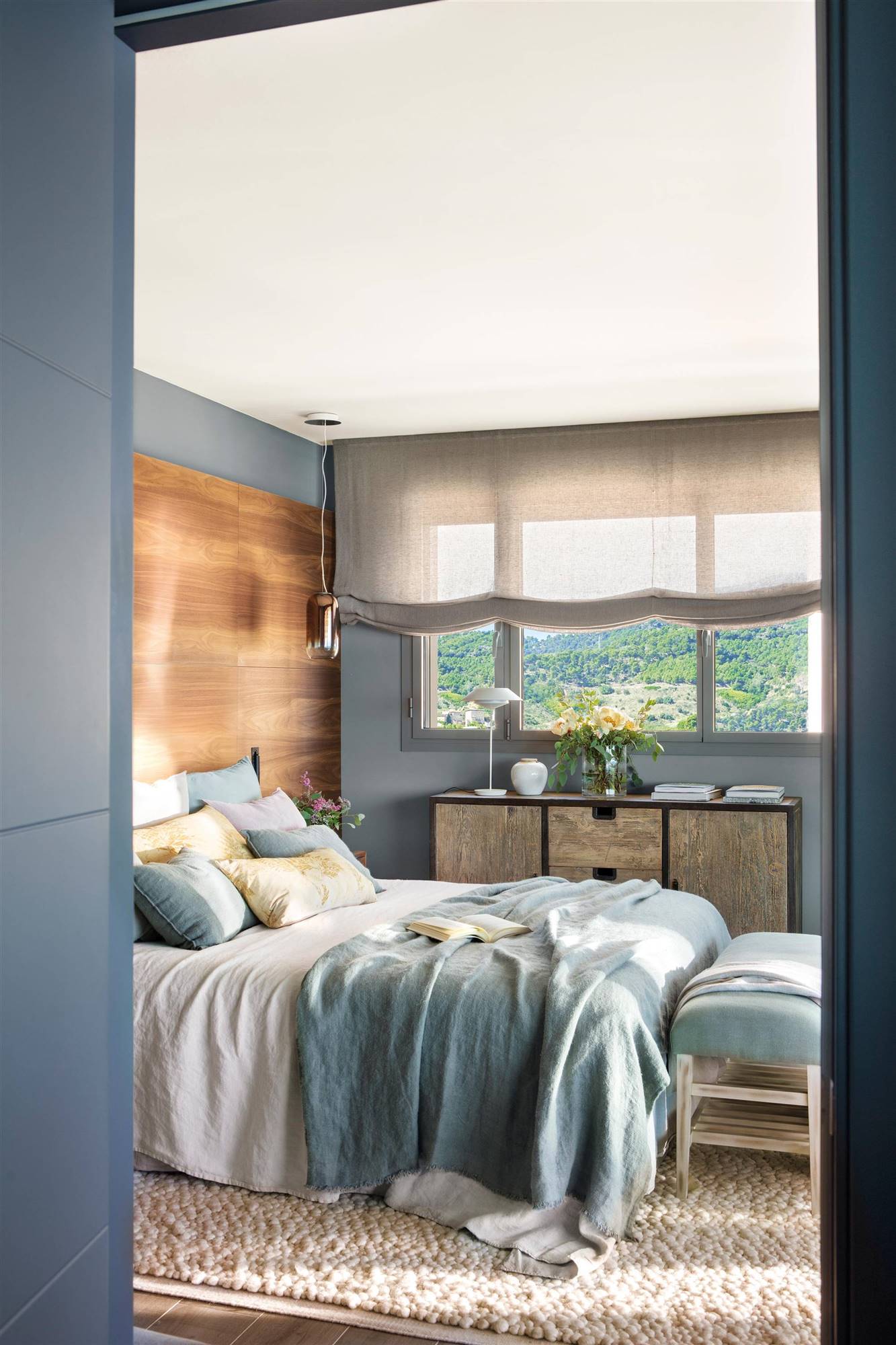 Dormitorio en azul con cabecero de madera