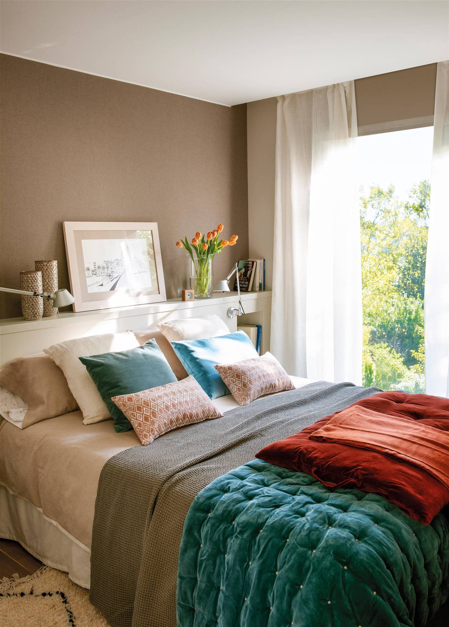 Dormitorio con cabecero a medida con hornacinas y papel pintado en color topo.