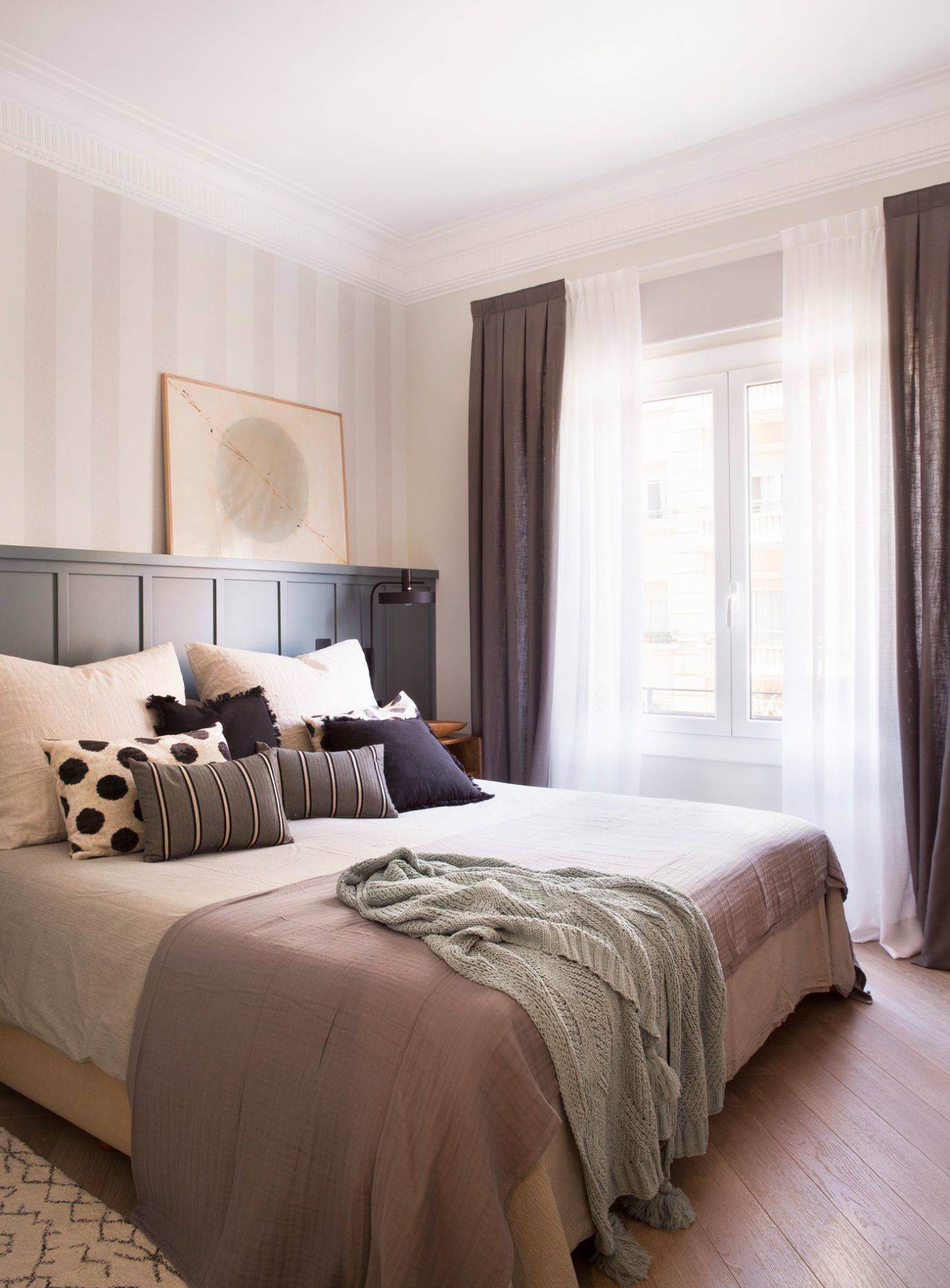 Dormitorio con cabecero hecho a medida y ropa de cama en tonos blancos y rosas. 