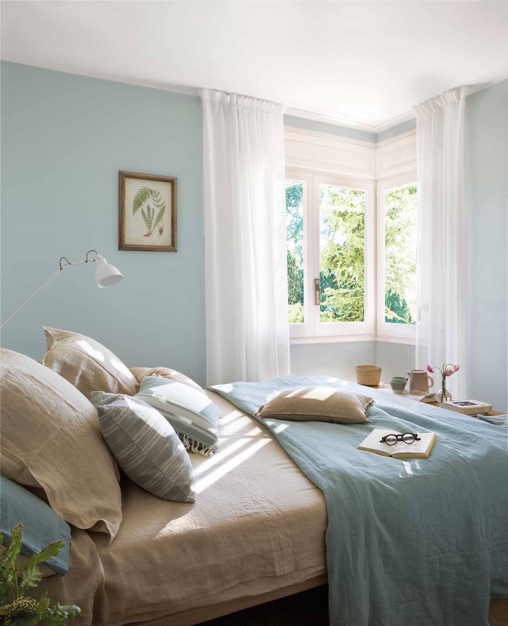 Dormitorio azul celeste con cortinas vaporosas.