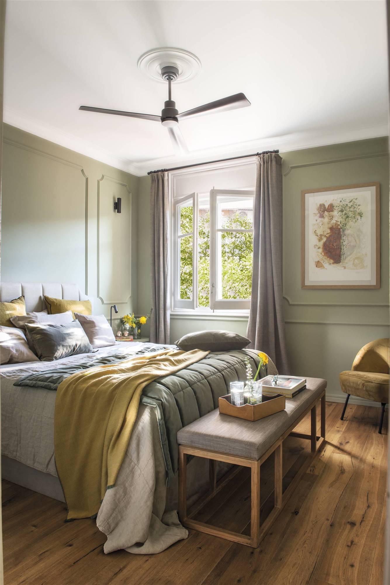 Dormitorio verde empolvado elegante con molduras y banqueta.