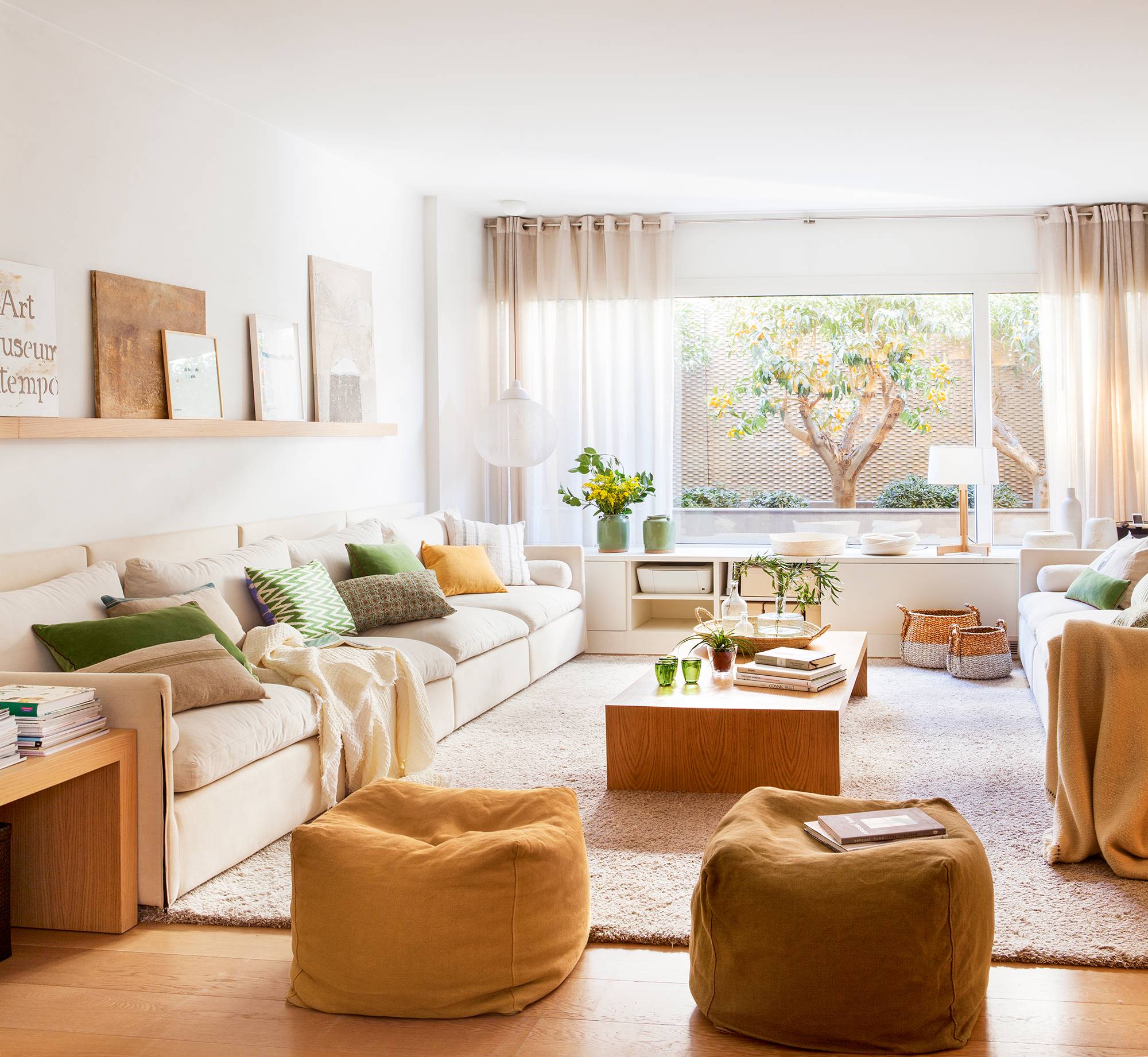 Salón con sofá beige, alfombra de pelo y puffs en color tostado 00426437