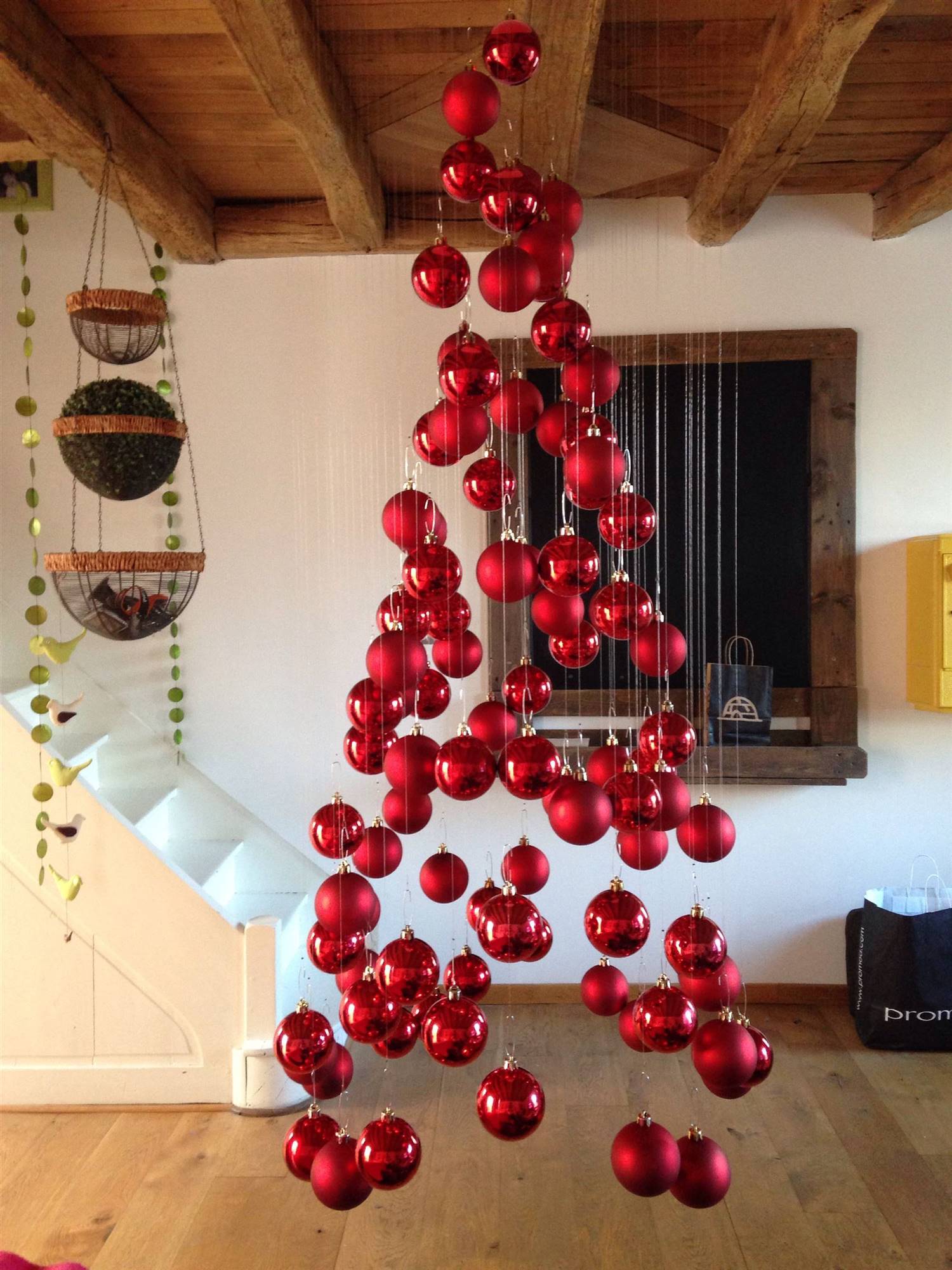 Bolas de Navidad colgadas del techo recreando un árbol.