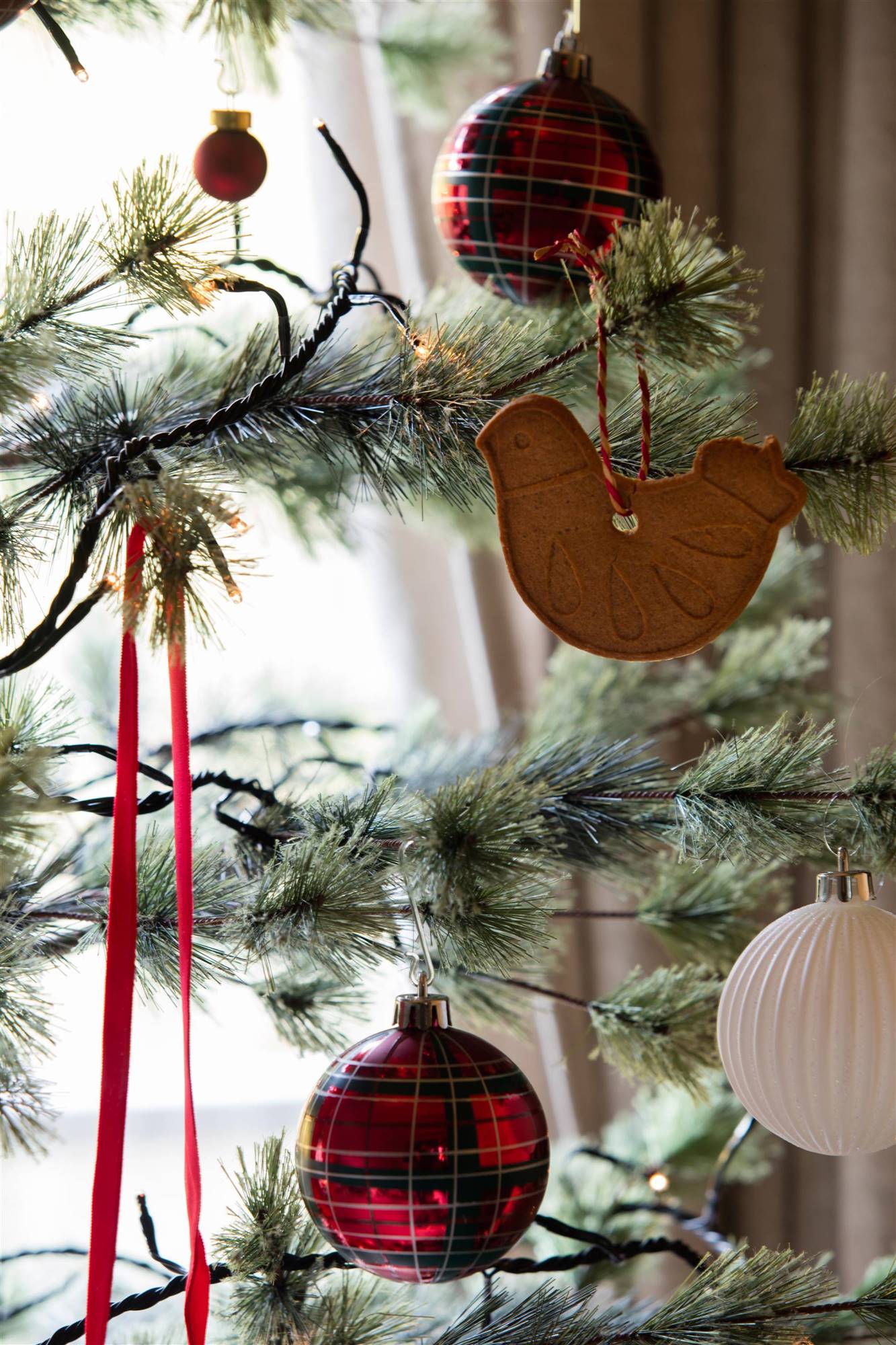 Detalle de árbol de Navidad con bolas de cuadros y galletas. 