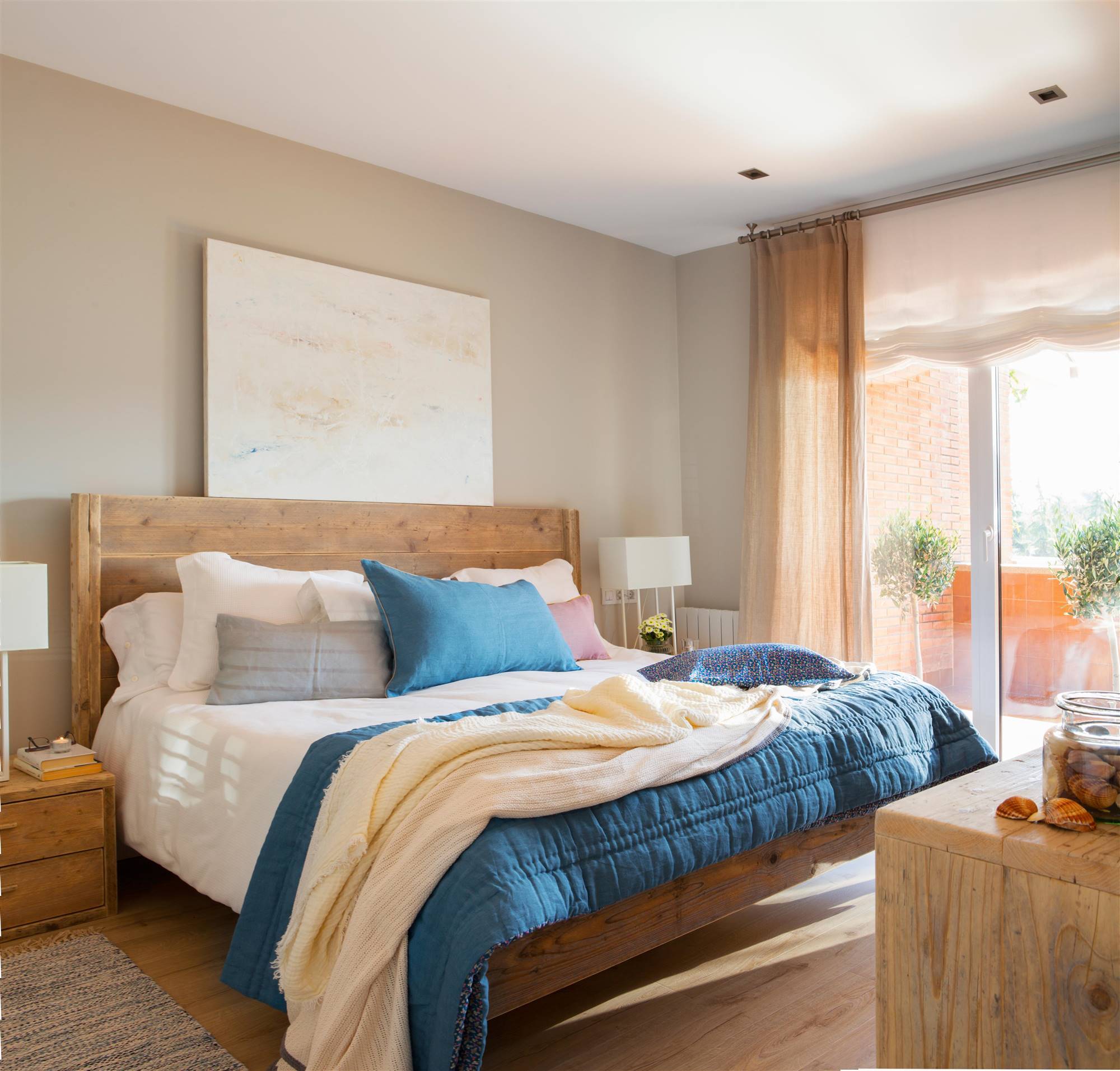 Dormitorio con muebles de madera y cabecero realizado con una puerta antigua de madera maciza.