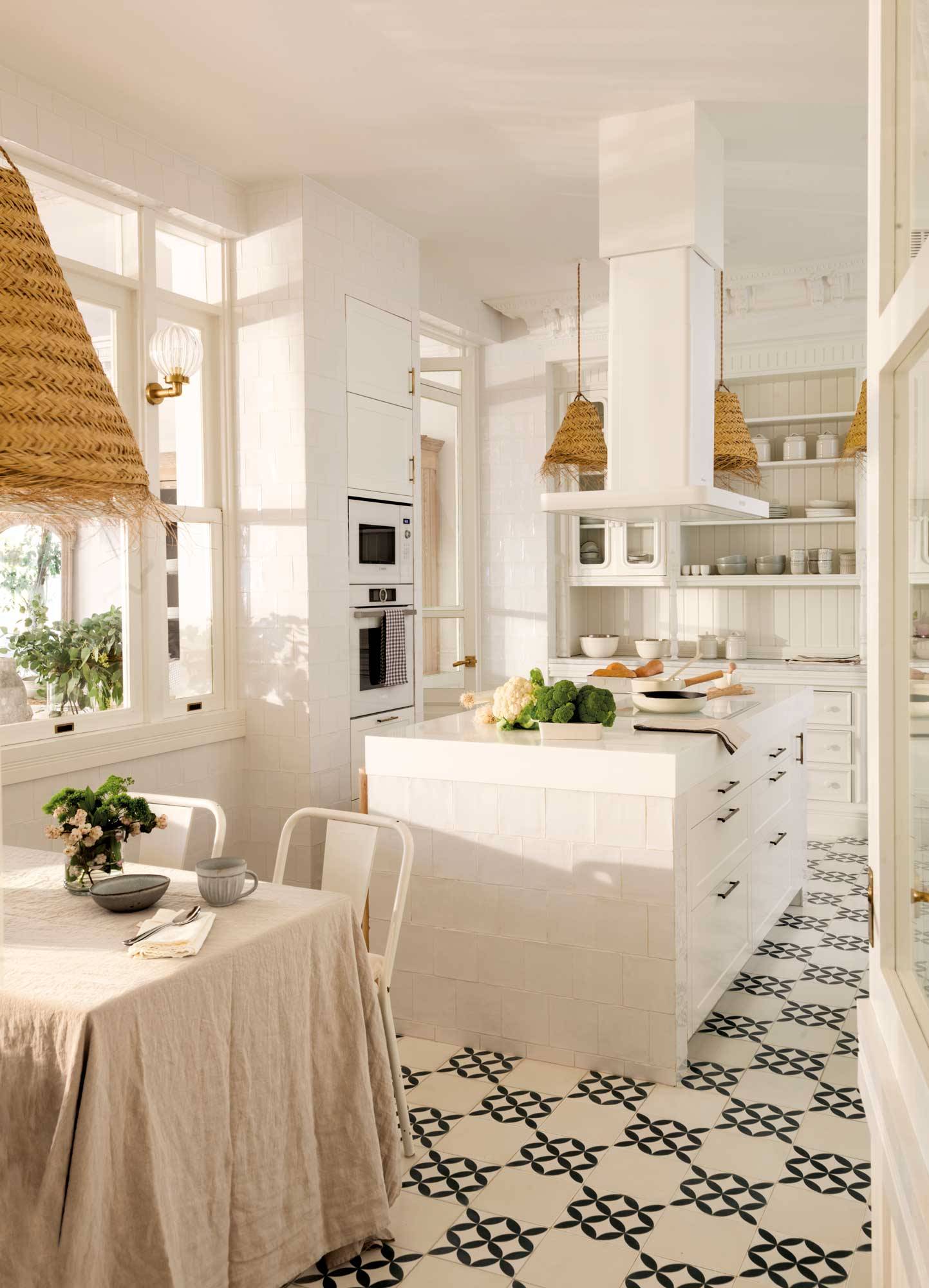 Cocina blanca con isla, azulejos y lámparas de fibras.