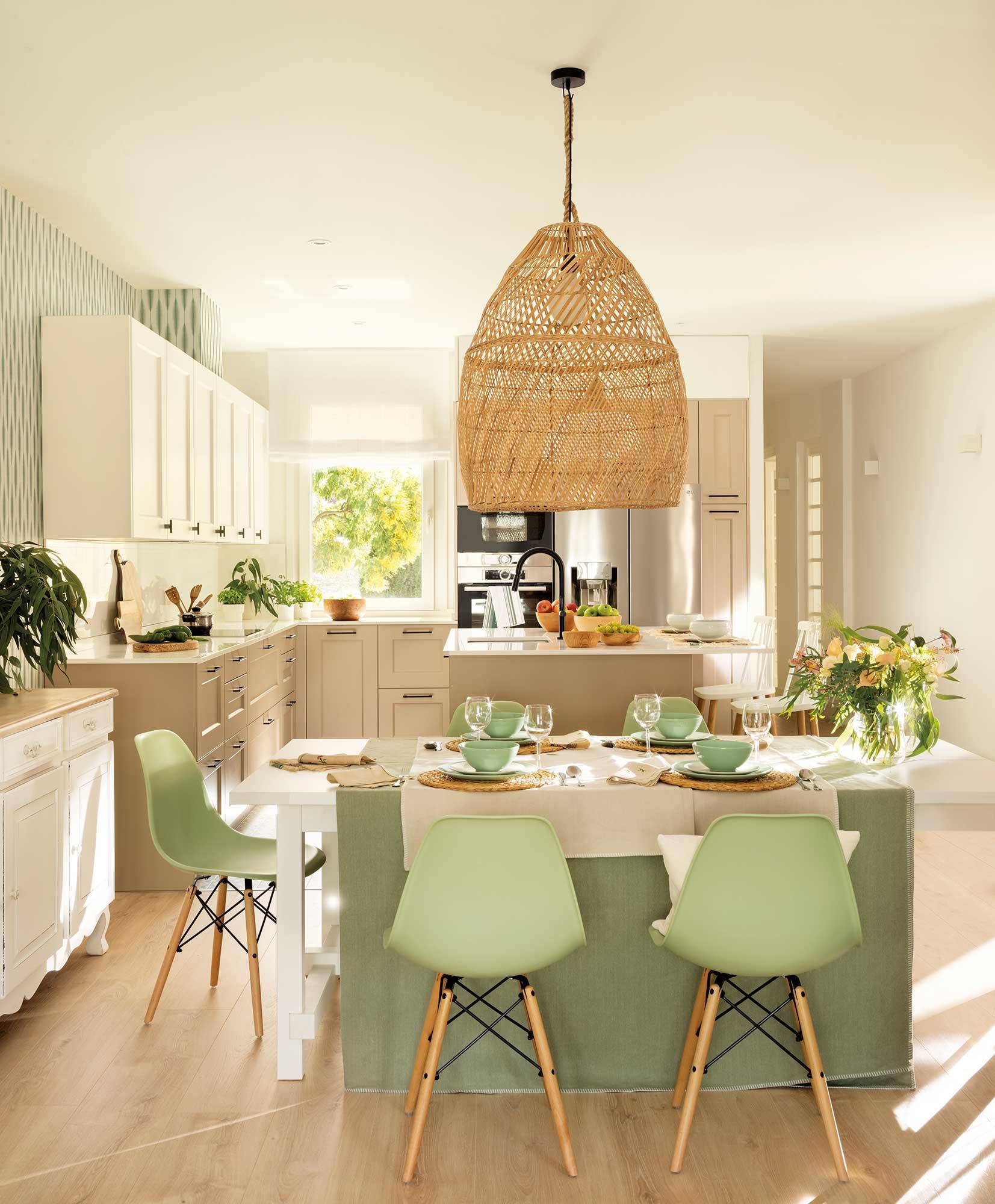 Comedor abierto a la cocina con sillas verdes de Vitra.