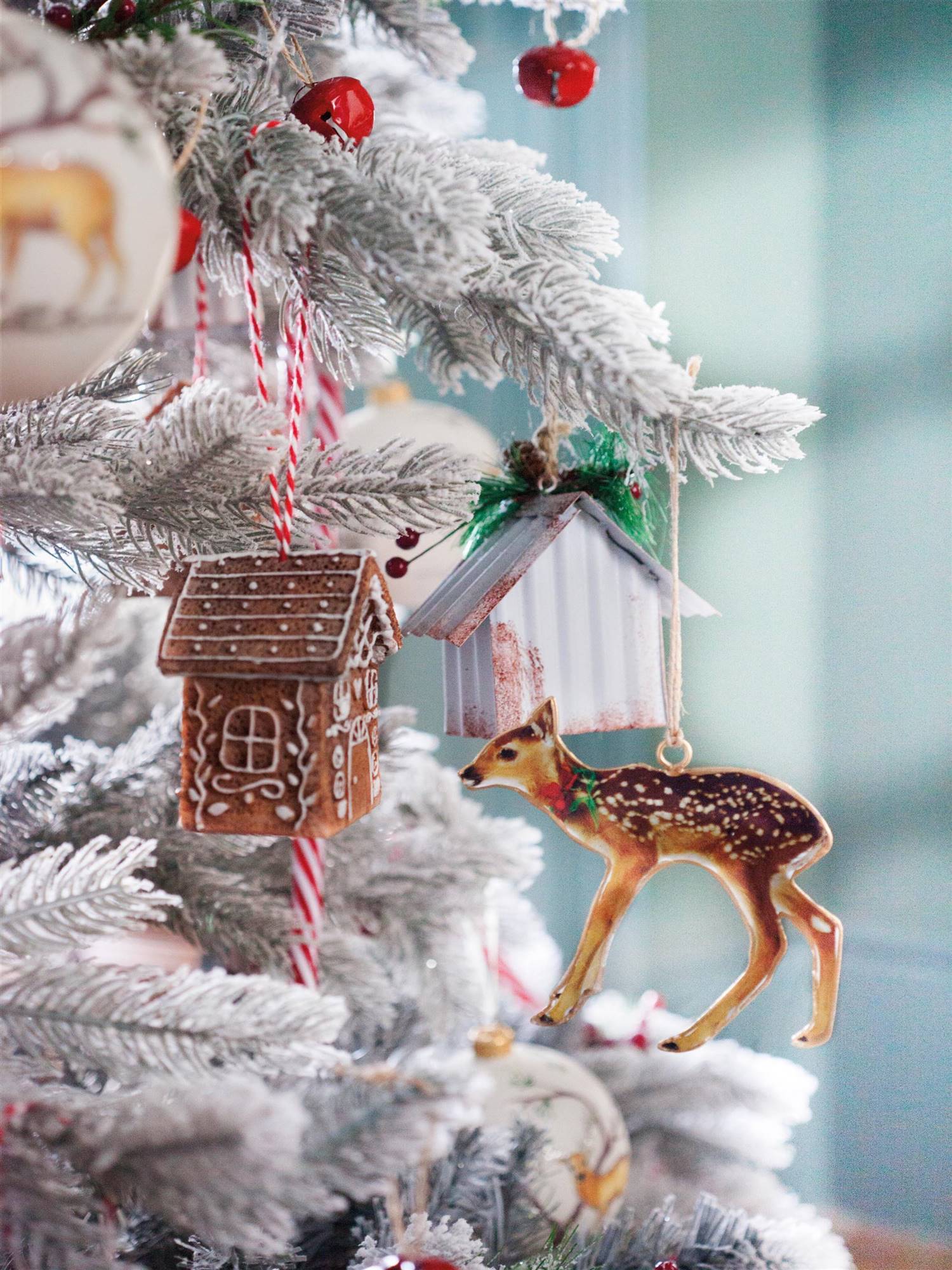 Figuras de adorno en un árbol de Navidad blanco.