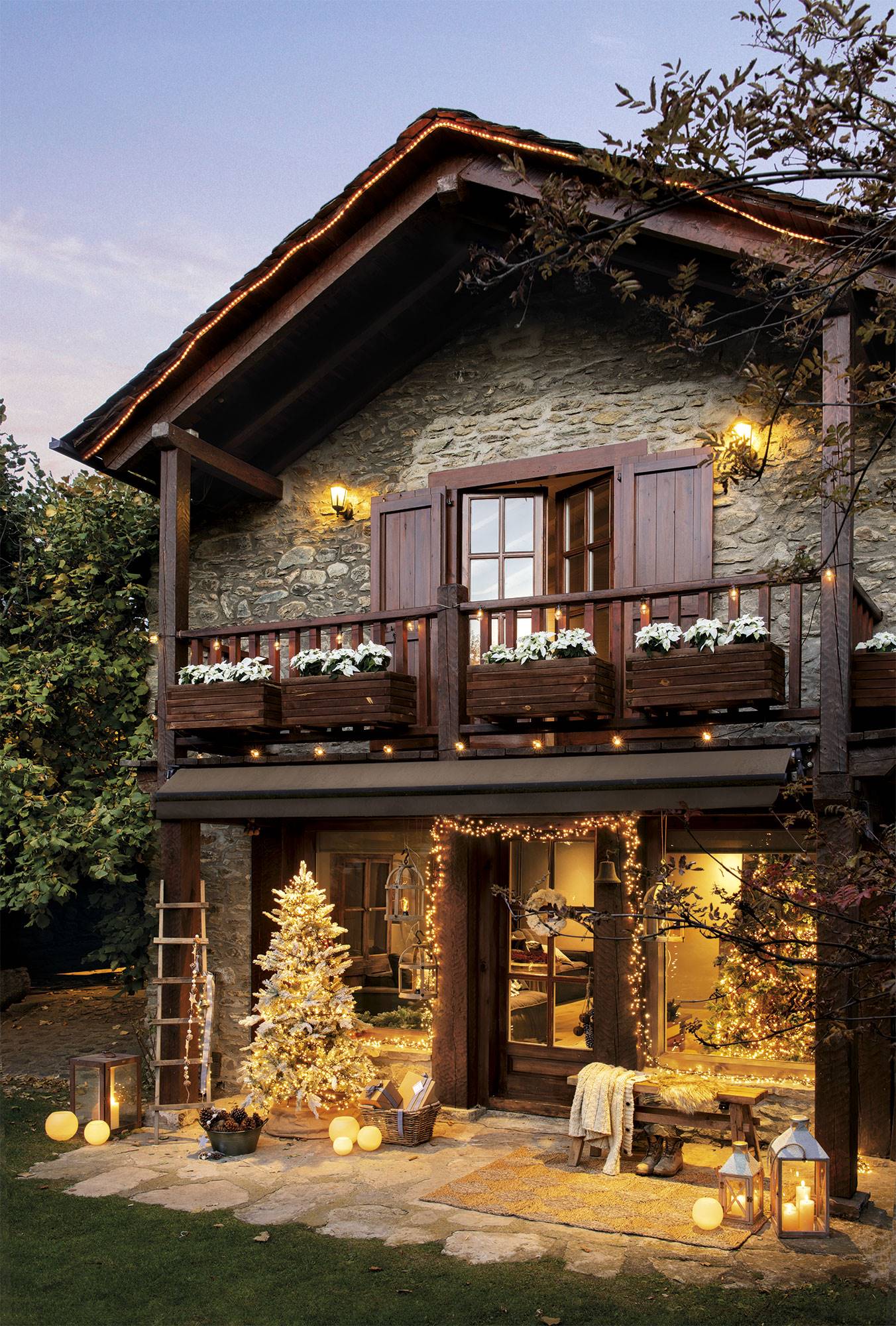 Fachada de madera y piedra con decoración navideña.