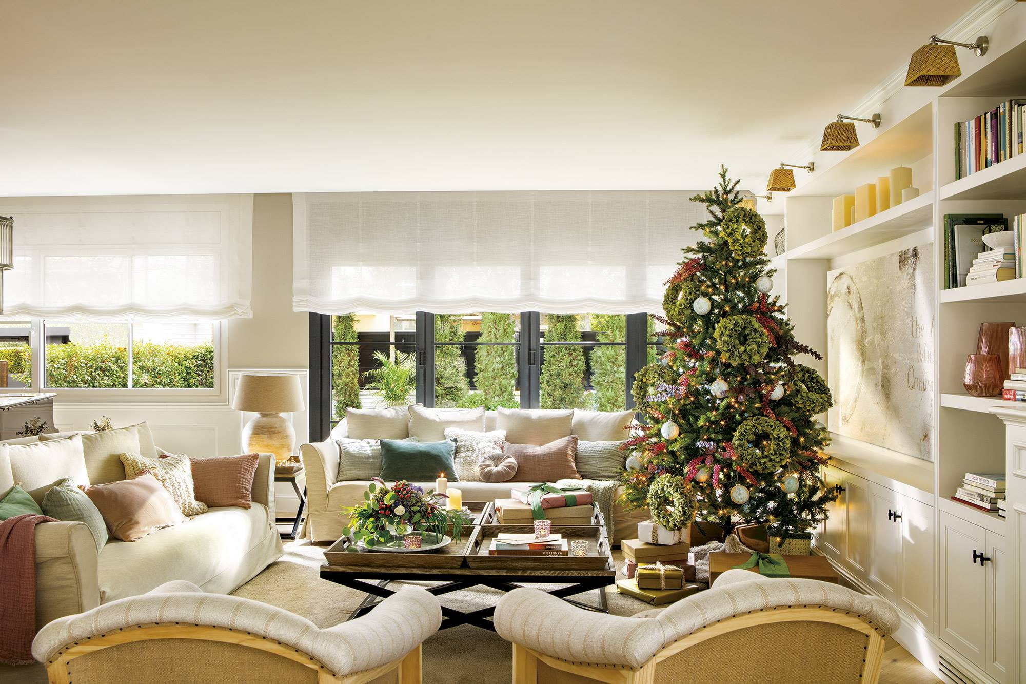Salón con sofás y butacas beige decorado por Navidad. 
