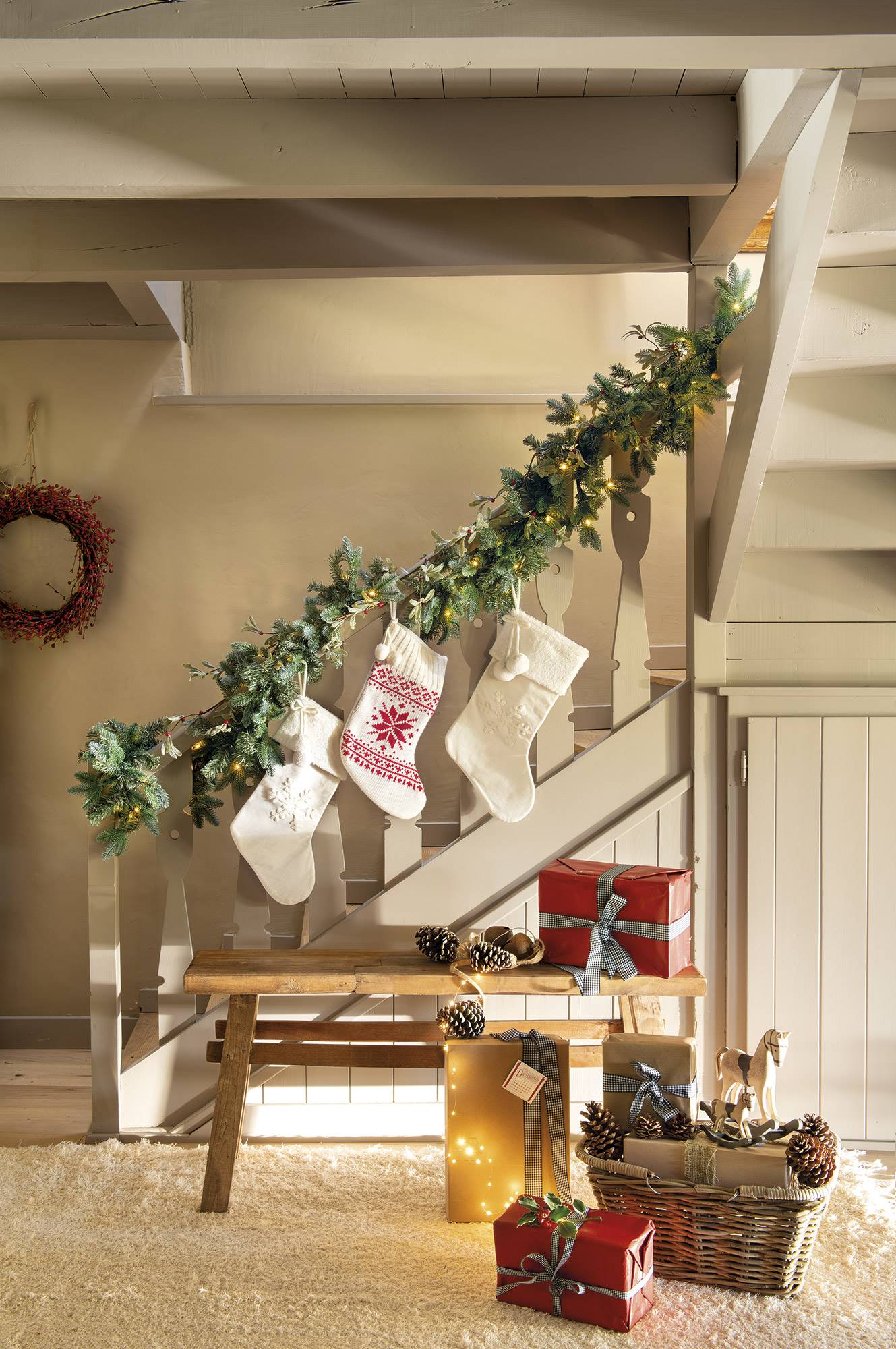 Una guirnalda con luces y calcetines navideños decoran la escalera.