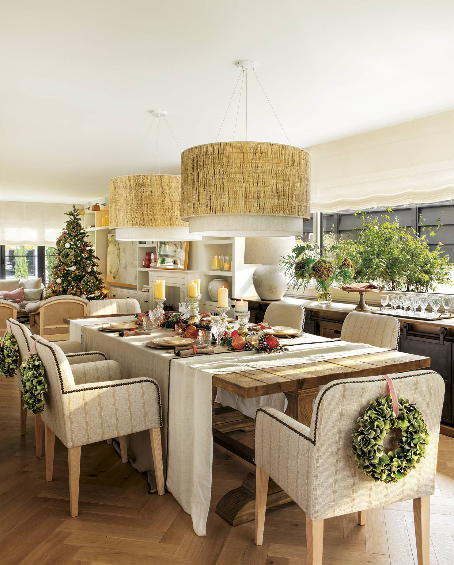 Comedor con mesa de madera y sillas tapizadas decorado por Navidad. 