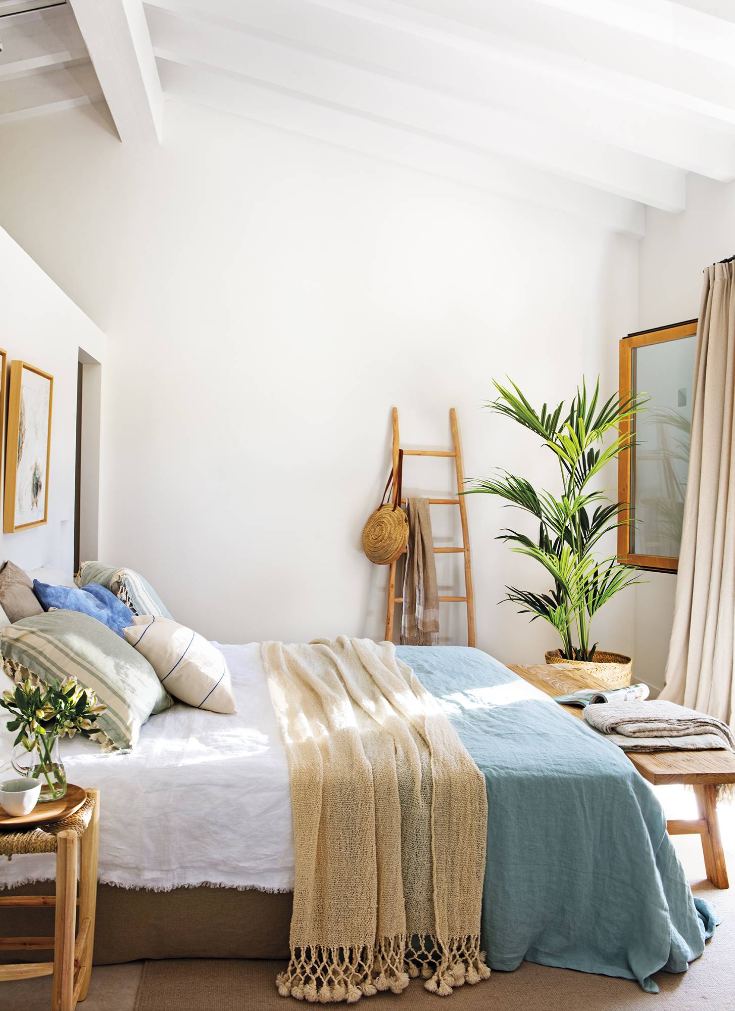 Dormitorio con cama en beige y azul y palmera 00508445