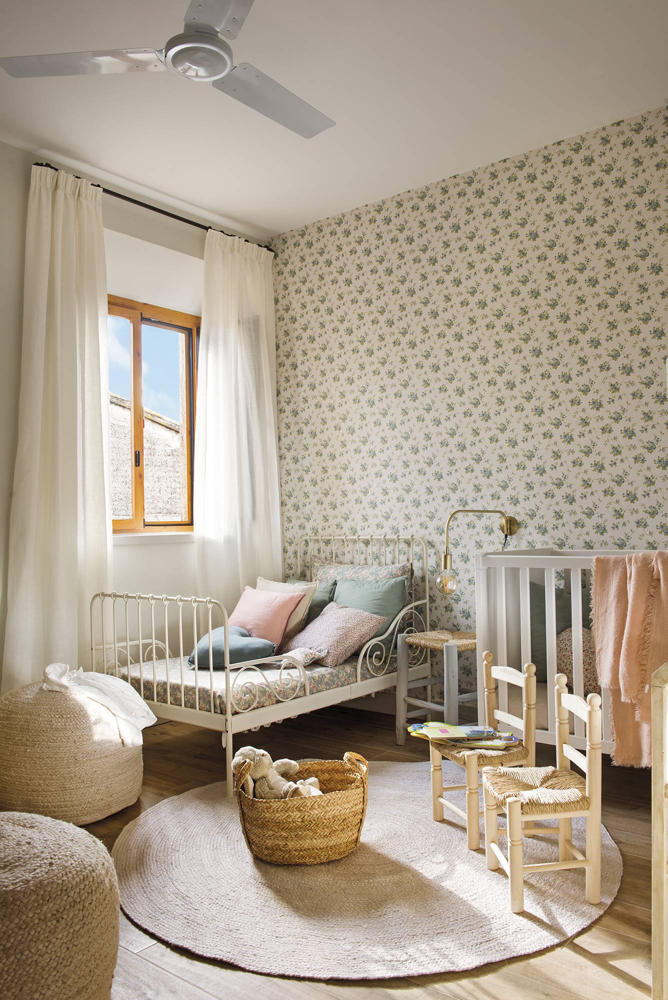 Habitación infantil con cama de forja blanca y cuna, muebles de fibras naturales y papel pintado floral DSC 8496