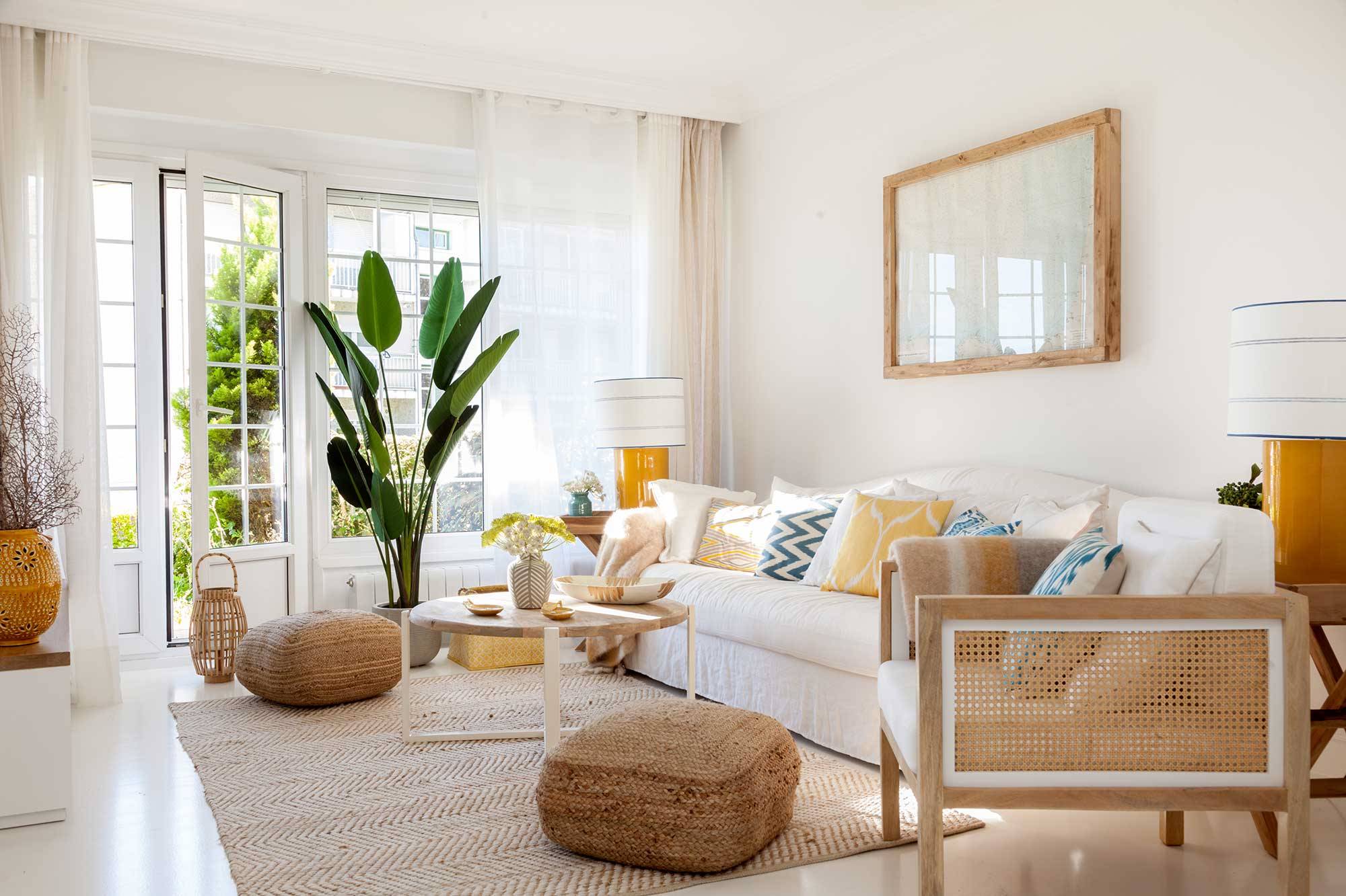 Salón con sofá de lino blanco, butaca de rejilla, pufs y alfombra de fibras naturales MG 0099