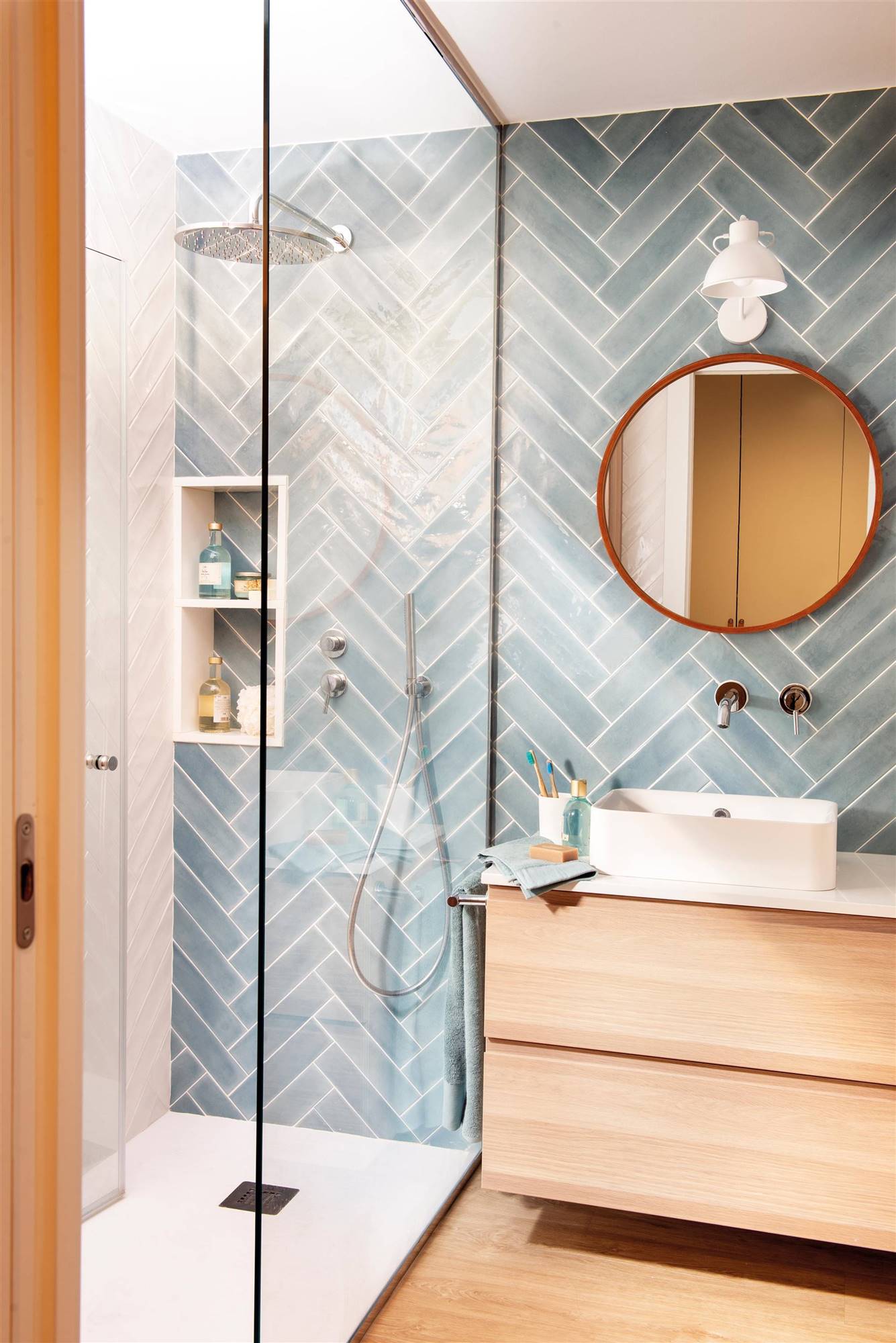 Baño con ducha, azulejos en espiga azules y mueble bajolavabo de madera suspendido 00523145