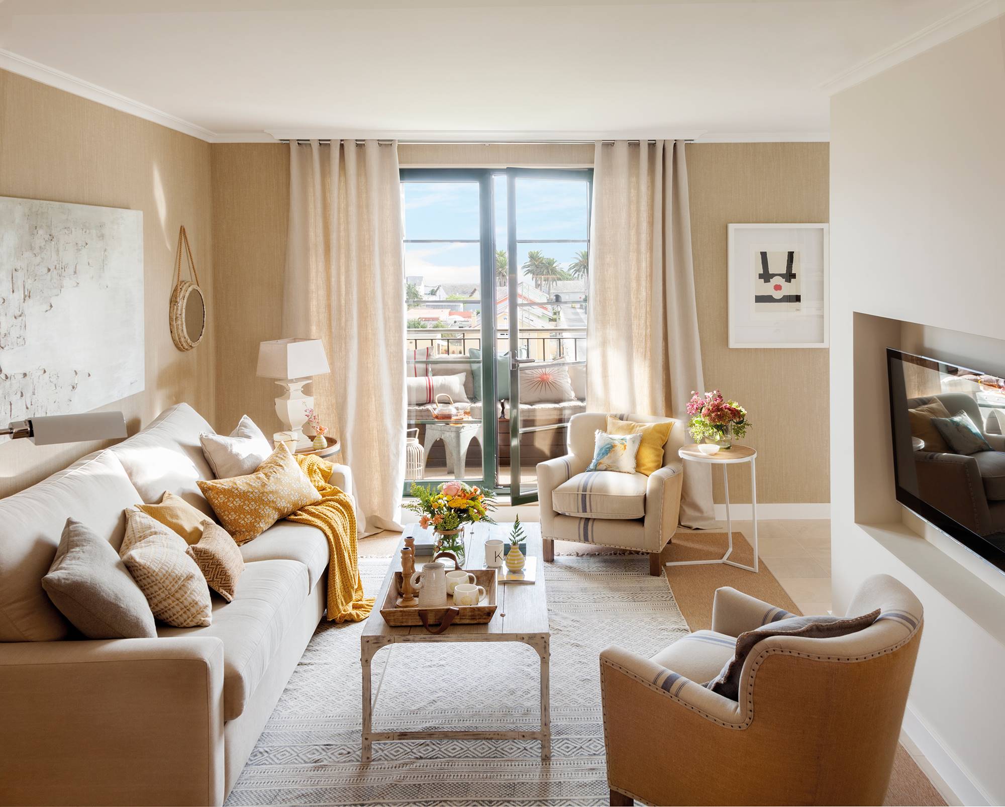 Salón decorado en beige con un sofá, dos butacas y una mesa de centro.