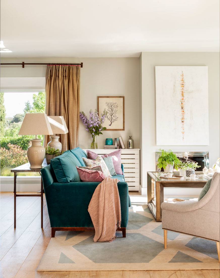 Ideas de decoración con un sofá verde combinado con cojines rosas. 