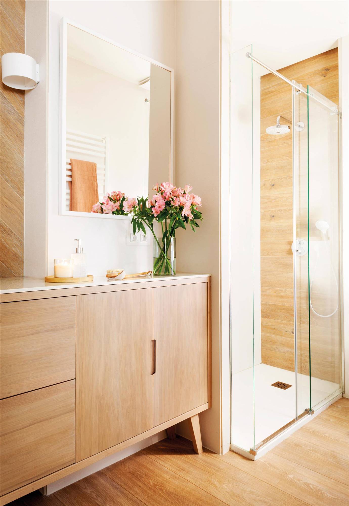 Baño blanco con mueble nórdico de madera y ducha revestida de madera. 