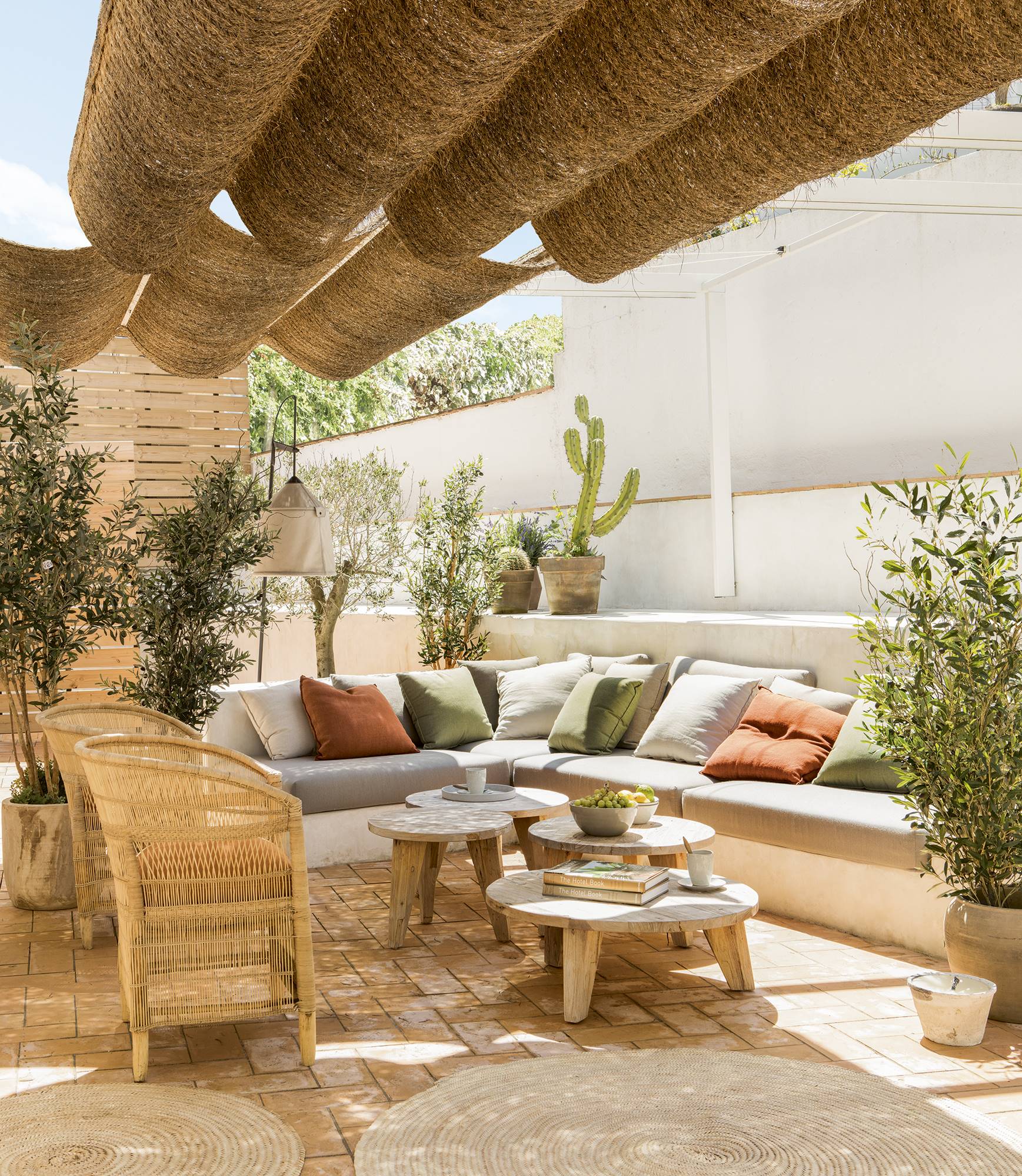 Terraza con butacas y un toldo de estilo mediterráneo. 
