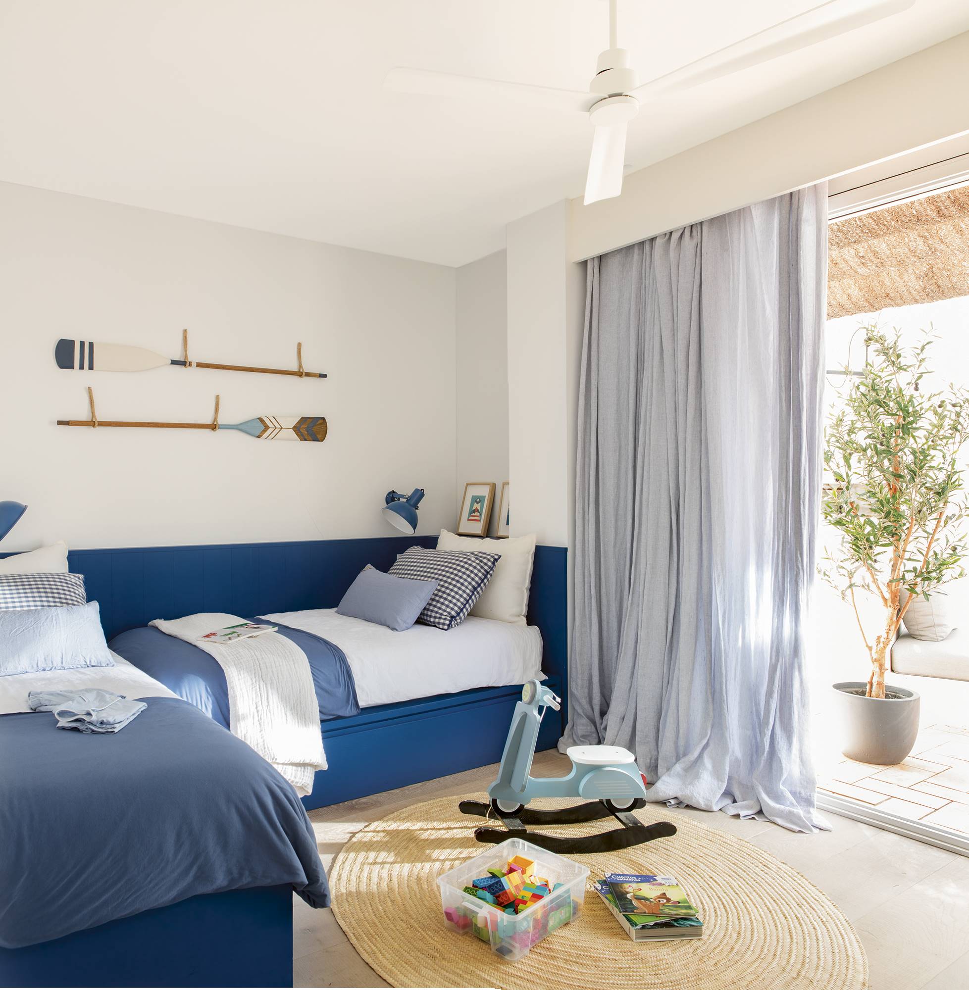 Dormitorio infantil con las camas y un arrimadero de color azul. 