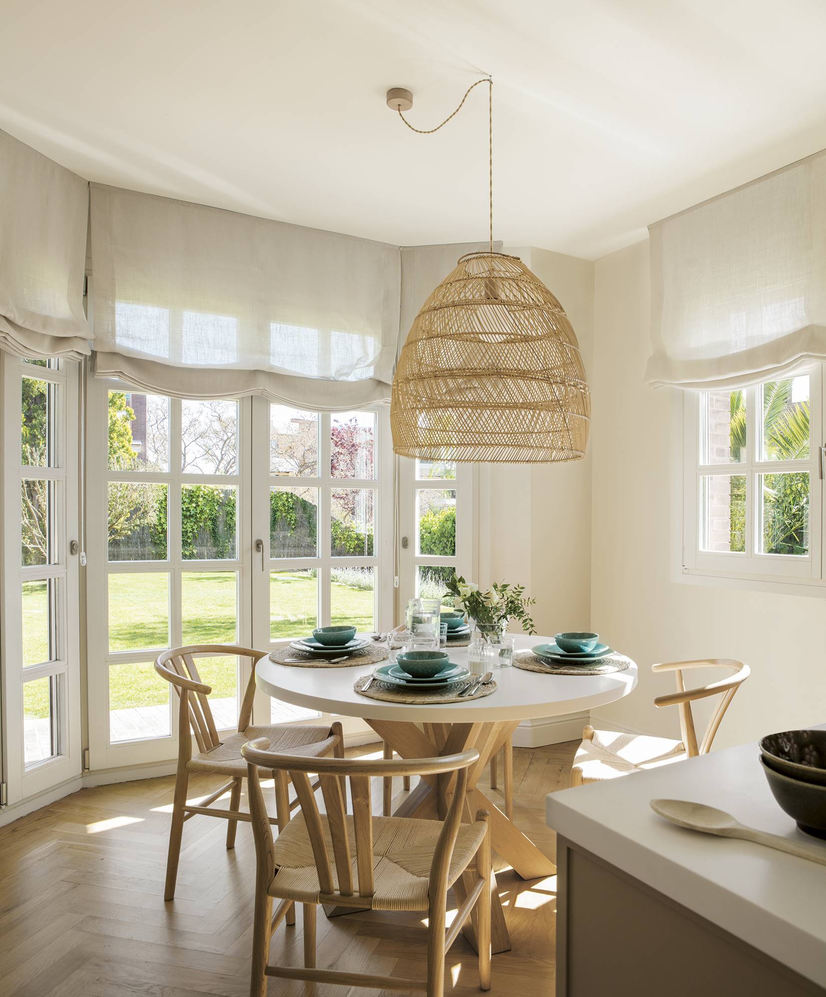 Office luminoso con mesa redonda y puertas acristaladas con cuarterones que comunican con el jardín.
