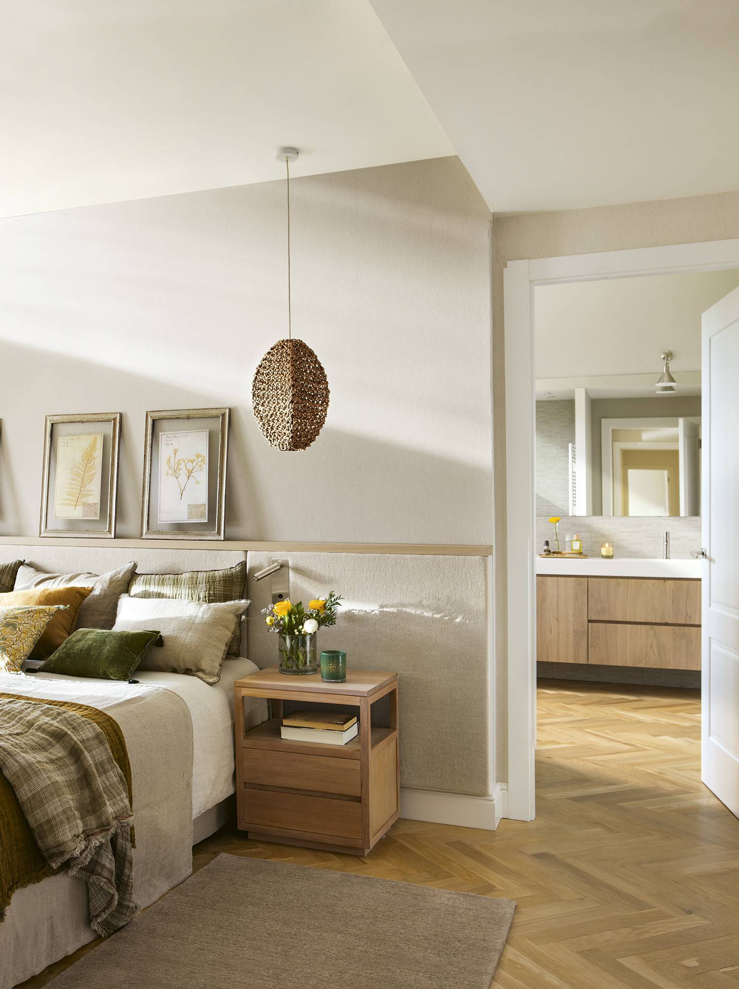 Dormitorio con baño en suite y cabecero rematado en madera barnizada