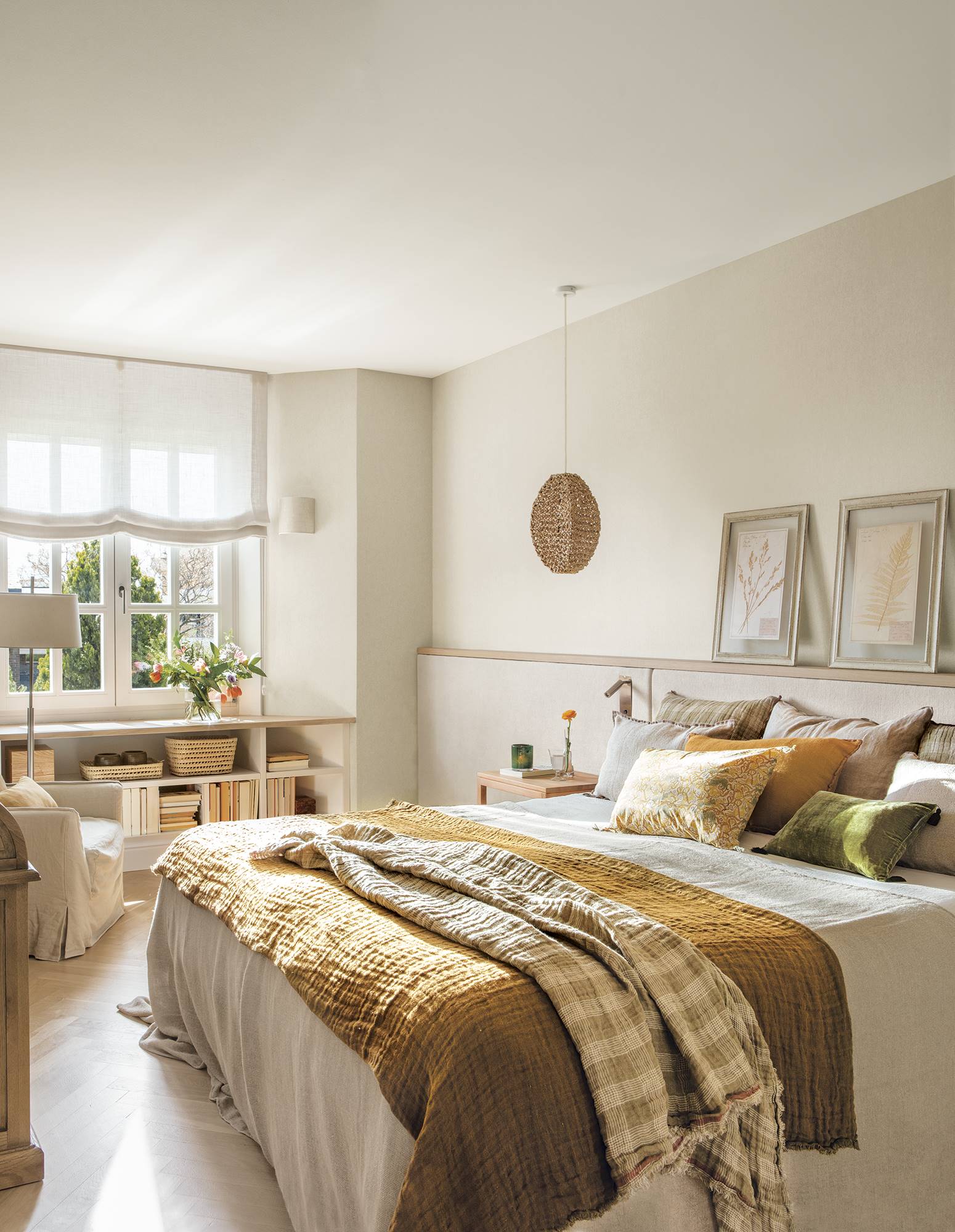 Dormitorio con cabecero a medida tapizado con tela, papel pintado en paredes y librería a medida bajo la ventana.