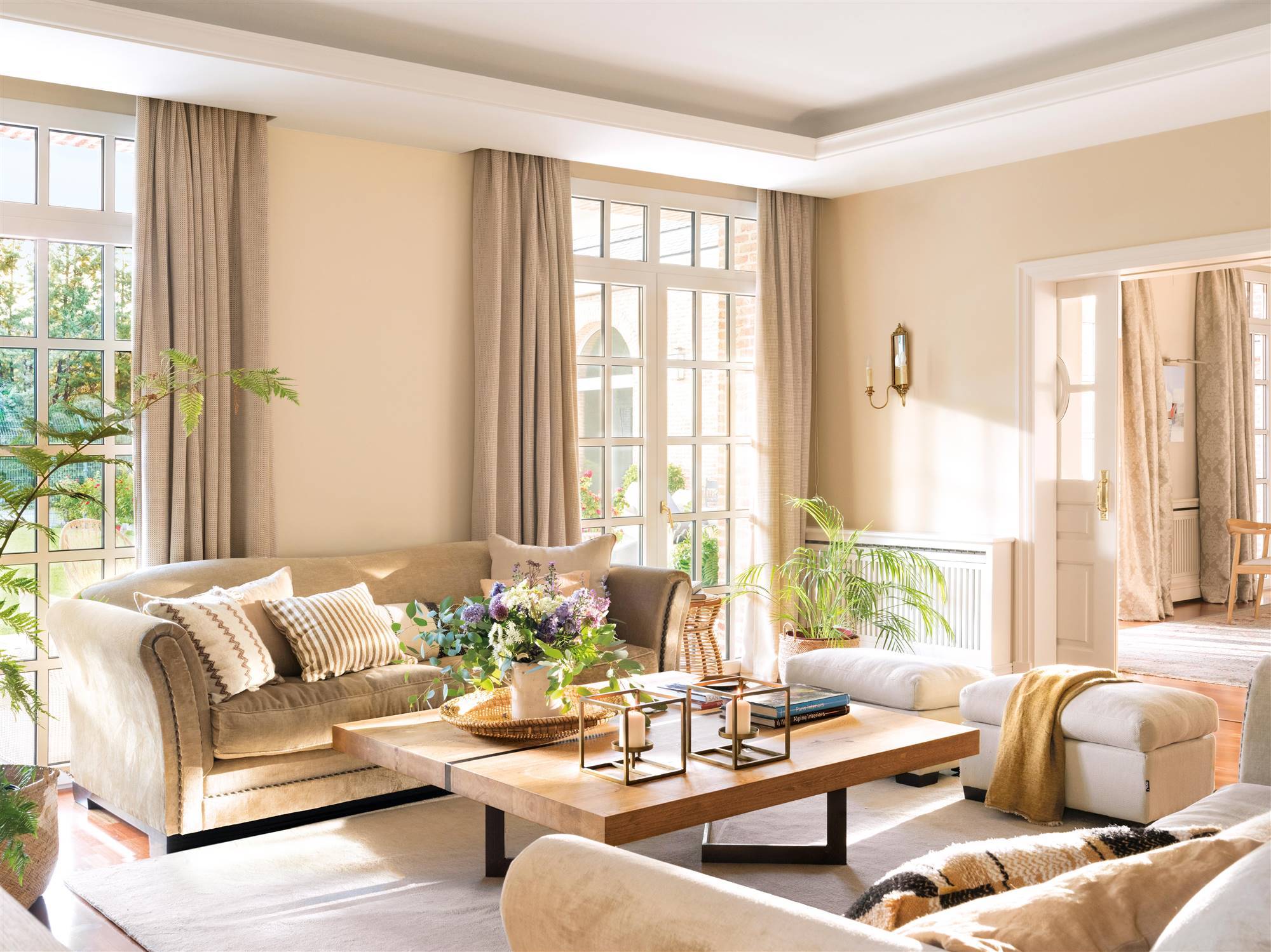 Salón en tonos beige y estilo clásico con sofá de terciopelo. 