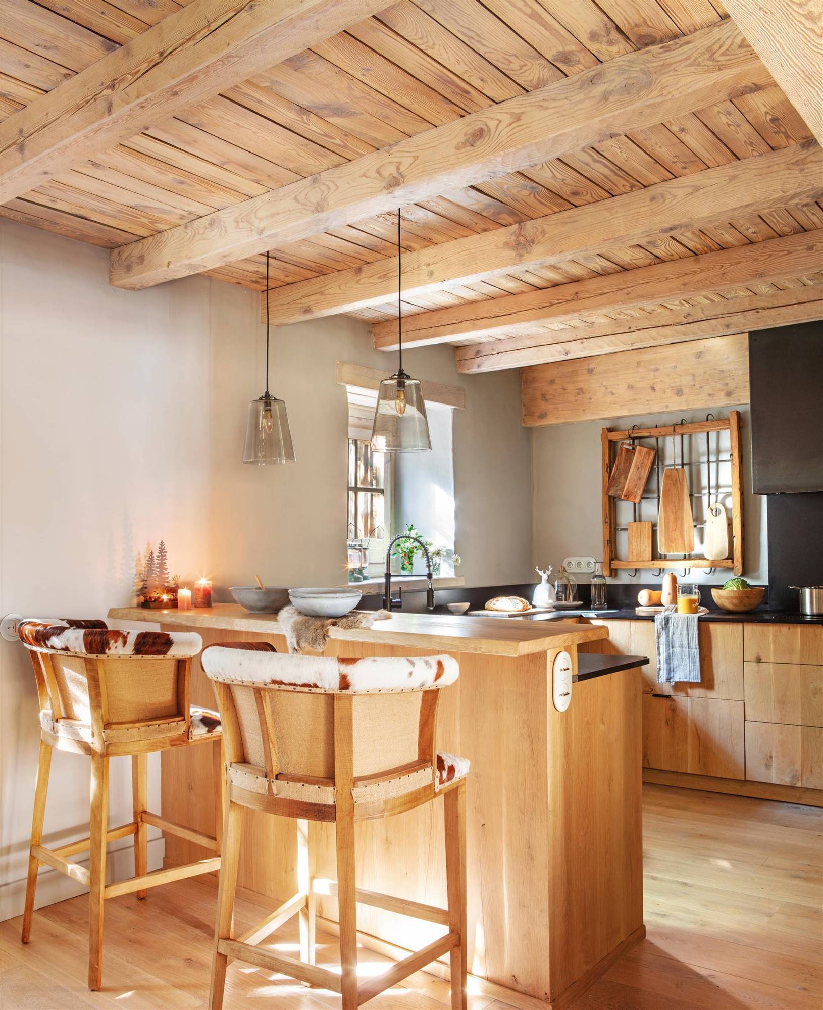Cocina rústica moderna panelada con madera y barra de desayunos. 