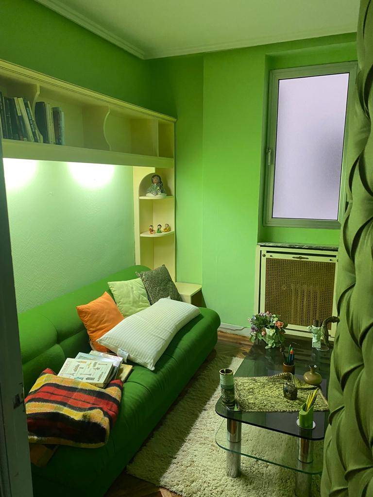 dd91a5ca-6dbc-48c9-b7c9-b60b4e5148ad. Antes: una habitación en tonos verdes desactualizada