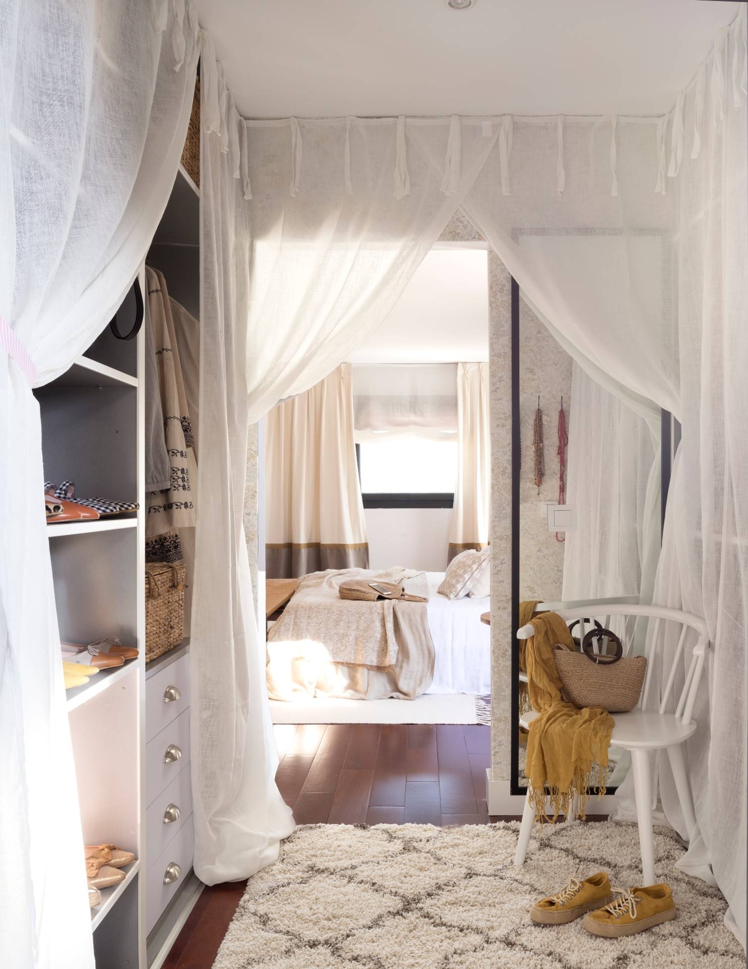Vestidor con armarios, abierto al dormitorio, y con cortinas de lino para preservar la intimidad