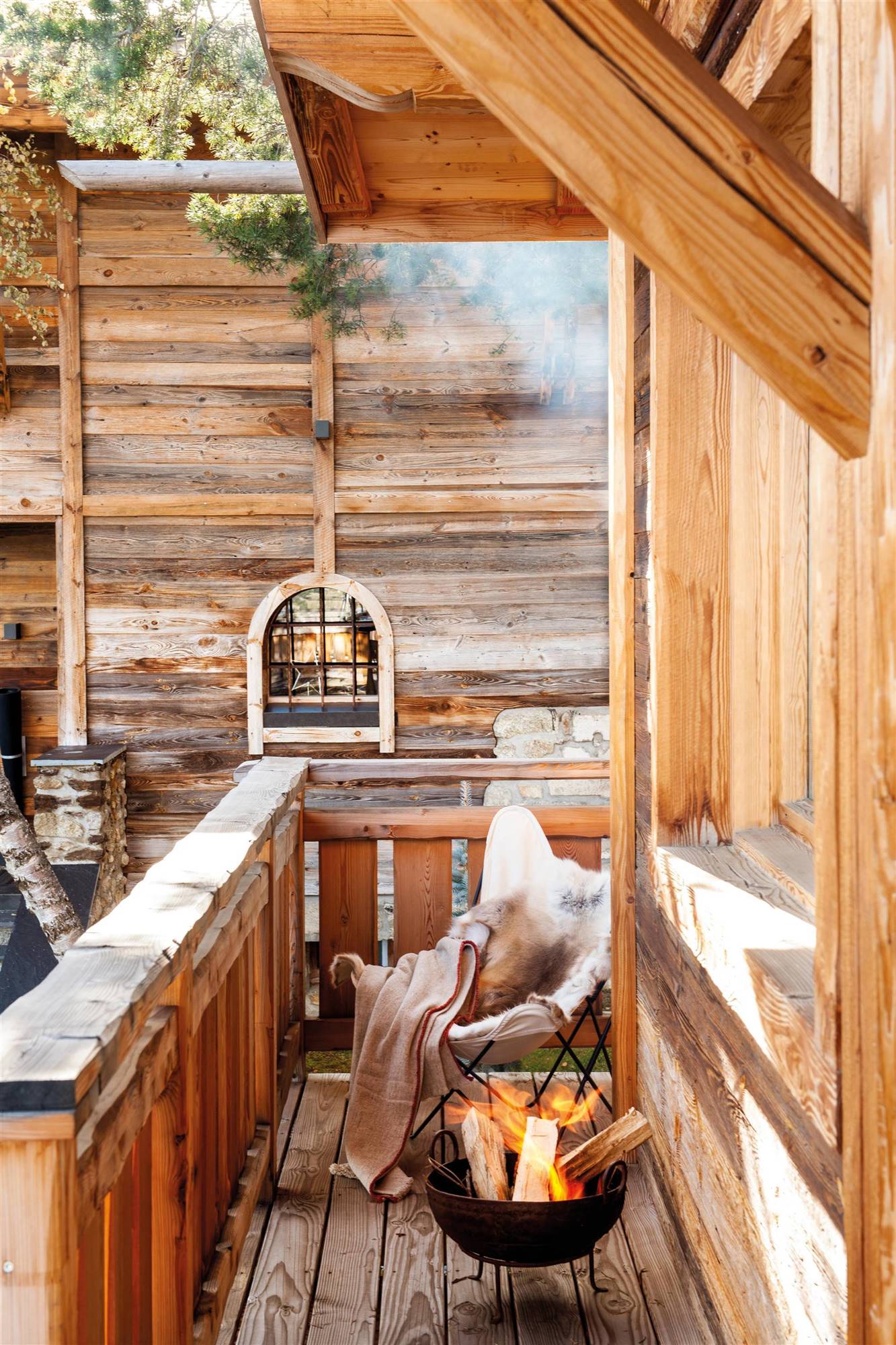 Terraza de madera tipo cabaña con estufa de leña.