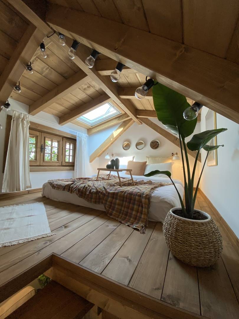 Un dormitorio en buhardilla con techo de madera.